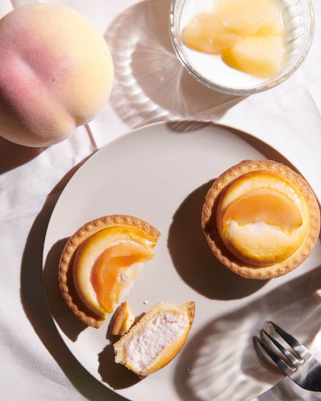 BAKE CHEESE TART OFFICIALのインスタグラム：「焼きたてチーズタルト ももヨーグルト🍑  🍑みずみずしい完熟白桃 🍑濃厚でなめらかなギリシャヨーグルト  おすすめの食べ方は、冷蔵庫で冷やすこと。  チーズムースとヨーグルトが 「ぎゅっ」と凝縮し 美味しく召し上がっていただけます😋  今だけの期間限定商品となりますので、 ぜひこの機会をお見逃しなく。」