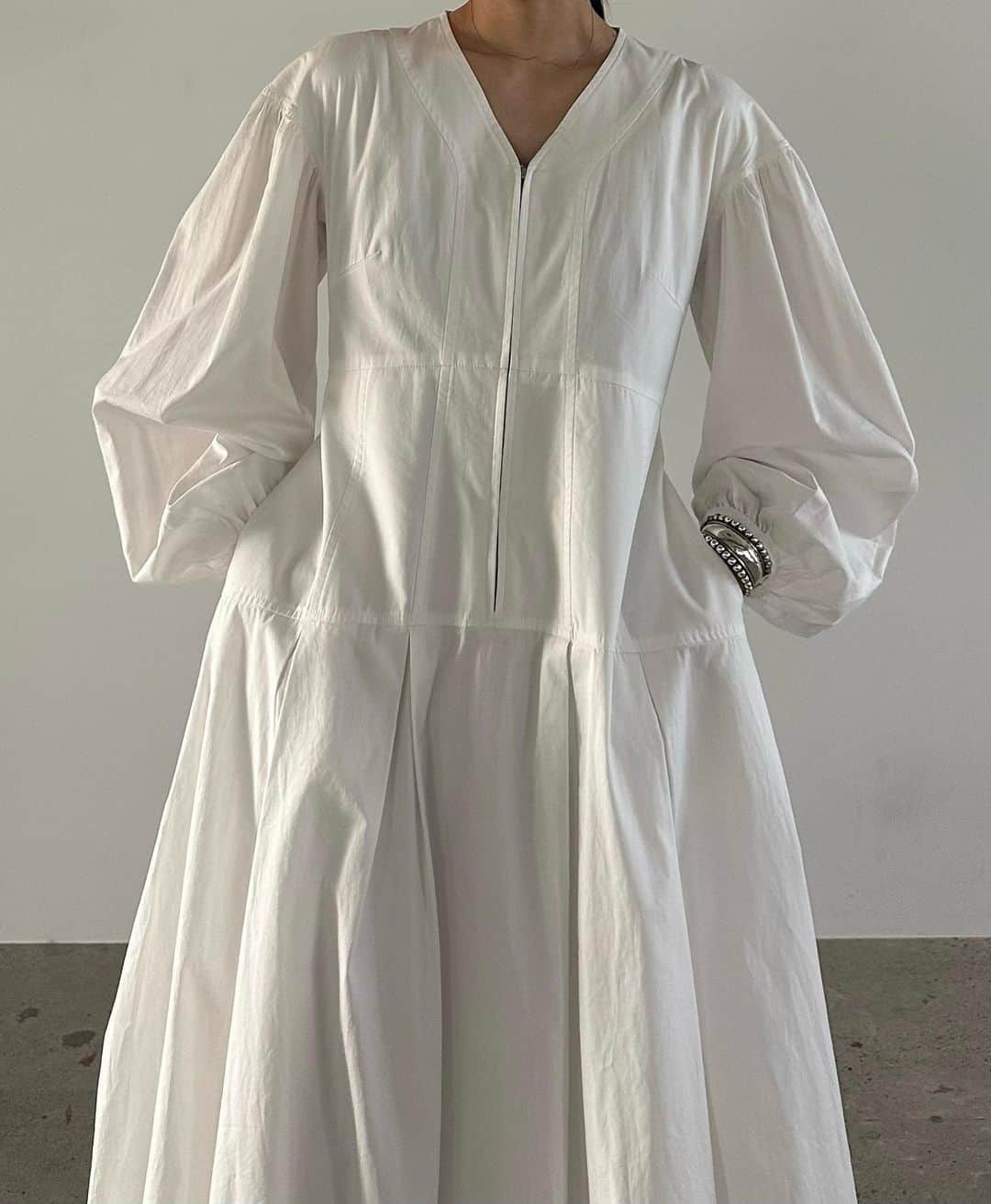 AICOのインスタグラム：「23AW PREORDER ITEM <Front zip balloon onepiece> ニットベストの下に着ていたワンピース。構築的なカッティングでシルエットを作り、コルセットのようなウエスト切り替えでボリュームがありながスタイルが綺麗に見える様に仕上げました。Vネックでデコルテがすっきり見え、フロントのファスナーディテールが甘さの中にエッジをだしています。バルーンのボリュー感もとても可愛い。素材は程よい肉感のコットン素材でカジュアルに着て頂けます。一枚でとても映えるワンピースなのでおすすめです。 #clane#clane23awpreorder」