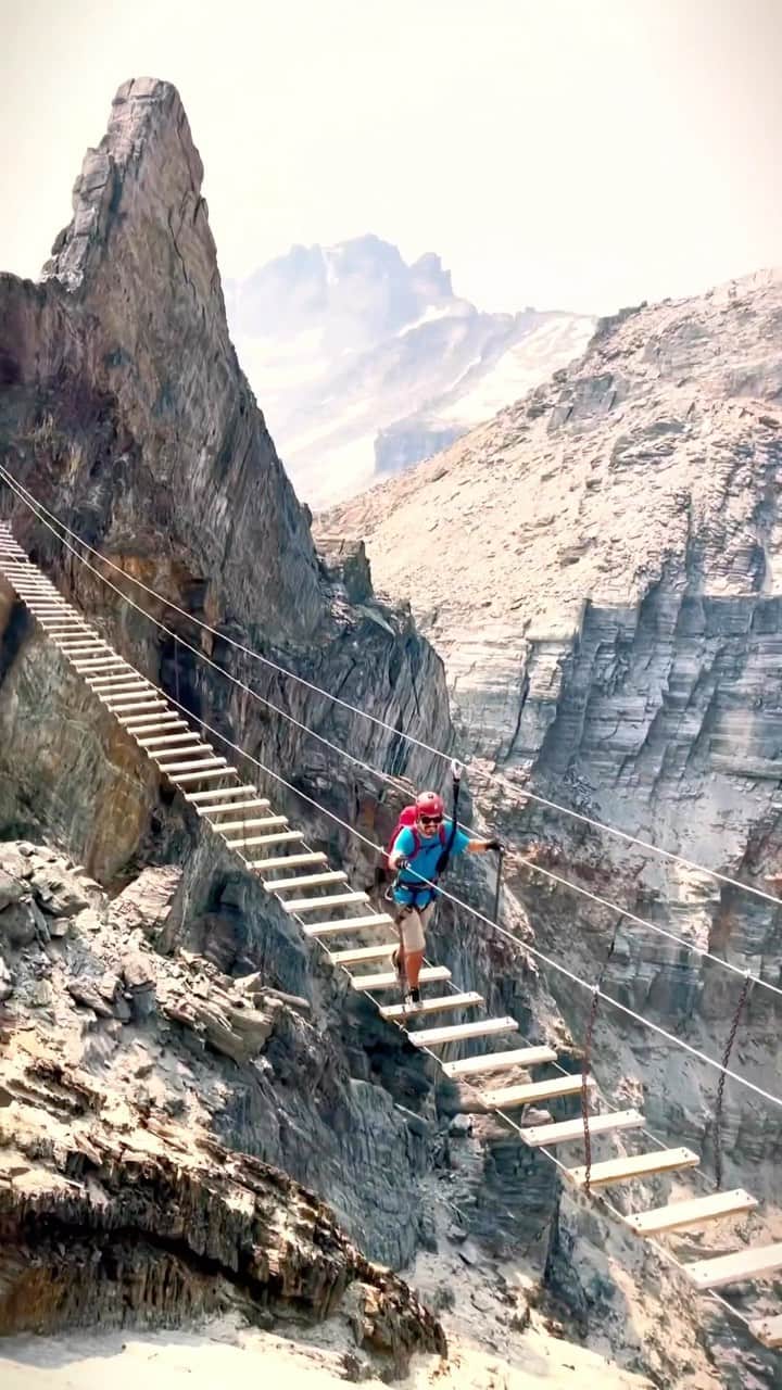 Explore Canadaのインスタグラム：「Do you have what it takes to conquer the Mt. Nimbus via-ferrata and suspension bridge? 😮   🚁 This hike is only accessible by helicopter while heli-hiking at CMH Bobbie Burns (@cmh_heli).  📷: @cmh_heli 📍: CMH Bobbie Burns, @hellobc   #CMHHeli #CMHBobbieBurns #ExploreBC   [Video description: People walk across a suspension bridge that connects two mountain peaks. They all wear helmets and are clipped onto the bridge for safety.]」