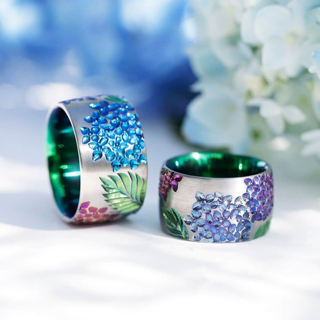 のインスタグラム：「#結婚指輪SORA 【AJISAI-紫陽花-】 紫や青の濃い花弁の色と緑の葉の色のコントラストが 初夏のしっとりとした季節を表現する結婚指輪＊*  内側に鮮やかなグリーンの発色を施すことで 大きな紫陽花の葉の存在を感じさせます。  ひとつひとつ丁寧にタガネで彫られた花弁は 手加工だからこその繊細な美しさを放ち、 細部に宿る美を日々堪能できるデザインです。  紫陽花 取扱店 ￣￣￣￣￣￣ ・SORA表参道本店 ・SORA札幌店  - - - - - - - - - - - - - - - - - - - -   🟩LINEでもデザインのご相談が可能です >>>「SORA」と検索！  公式アカウントをお友だち登録して メッセージを送ってください  SORA表参道本店のデザイナーがご返信します💁‍♀️  - - - - - - - - - - - - - - - - - - - -   SORA公式サイトや店舗情報は アカウントTOPのURLからcheck * >>> @sora_omotesando  ぜひハッシュタグをつけて SORAの写真を投稿してください♪ >>> #結婚指輪SORA  デザイナー、クリエイターが皆さんの投稿を拝見し 毎日パワーをいただいています🌿  - - - - - - - - - - - - - - - - - - - -   #結婚指輪 #婚約指輪 #ペアリング #オーダーメイド結婚指輪 #結婚指輪オーダー #金属アレルギー対応リング #結婚指輪探し #マリッジリング #ブライダルリング #weddingring #サムシングブルー #紫陽花 #hydrangea #紫陽花の日 #ジューンブライド #junebride #プレ花嫁」