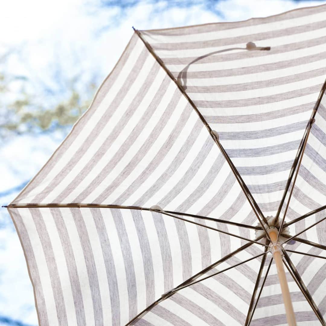 北欧、暮らしの道具店さんのインスタグラム写真 - (北欧、暮らしの道具店Instagram)「当店別注！毎日持ちたい、晴雨兼用のボーダー日傘。 . - - - - - - - - - - - -  本格的に日差しが強くなるこれからの季節。 お気に入りの日傘があれば、 暖かい季節の外出がもっと楽しくなりそうです。  そこでおすすめなのが、 落ち着いたボーダー柄がポイントの アンキャシェットの日傘。 当店でも毎年再販を繰り返している 人気のロングセラー商品なんです。  生地とパーツにとことんこだわって作った 当店別注のデザイン。 大人が毎日持てるような、 ちょうどいい可愛さに仕上がりました。  白×グレーのボーダー柄は どんなコーディネートにも フィットしてくれる万能カラー。 スカートはもちろん、パンツスタイルにも合うので カジュアル派の方にもおすすめです。  気になるUVカット率は90％以上！ 日差しが強い日にも、安心して お使いいただけます。  生地には撥水加工も施されているので、 急な雨も大丈夫。 晴雨兼用で、ますます出番も増えそうですね。  長傘と折りたたみ式の2タイプをご用意しました。  折りたたみ式の嬉しいところは、 毎日バッグに入れて持ち歩けるコンパクトさ。 お出かけの時はもちろん、通勤にもおすすめですよ。  ぜひコーディネートの仕上げに加えて、 春のお出かけを楽しんでくださいね。  ーーー 掲載のアイテムはこちら▼ ーーー . ☑︎Encachette/アンキャシェット/日傘  ▶︎ プロフィールのリンクから、お値段・サイズなど詳しい情報をご覧いただけますよ。→@hokuoh_kurashi . #fashion#coordinate#ファッション#コーデ#Encachette#アンキャシェット#日傘#傘#コーディネート#シンプルコーデ#今日のコーデ#お買い物#お買いもの#シンプル#シンプルライフ#シンプルデザイン#暮らしを楽しむ#日々の暮らし#北欧#暮らし#北欧暮らしの道具店」6月6日 13時01分 - hokuoh_kurashi
