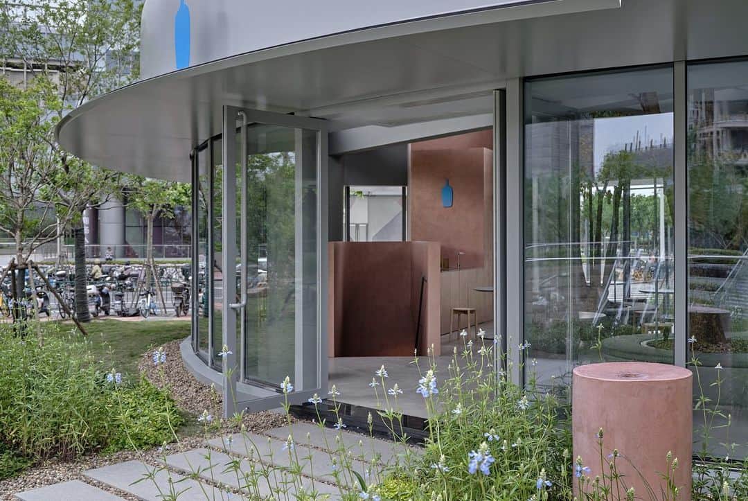 Blue Bottle Coffeeのインスタグラム：「Introducing our fifth cafe in Mainland China and the first in Pudong, Shanghai—the Qiantan cafe. It’s located in a public green space amongst the high-density international business district, bringing guests close to nature within the city.  We collaborated with Keiji Ashizawa Design, the designers of our JAKC location, to bring their experience with public green spaces to this cafe. They integrated modern architecture into the surrounding landscape to blur the boundary between interior and exterior.  Come visit our Qiantan cafe for a moment of peace in nature.」