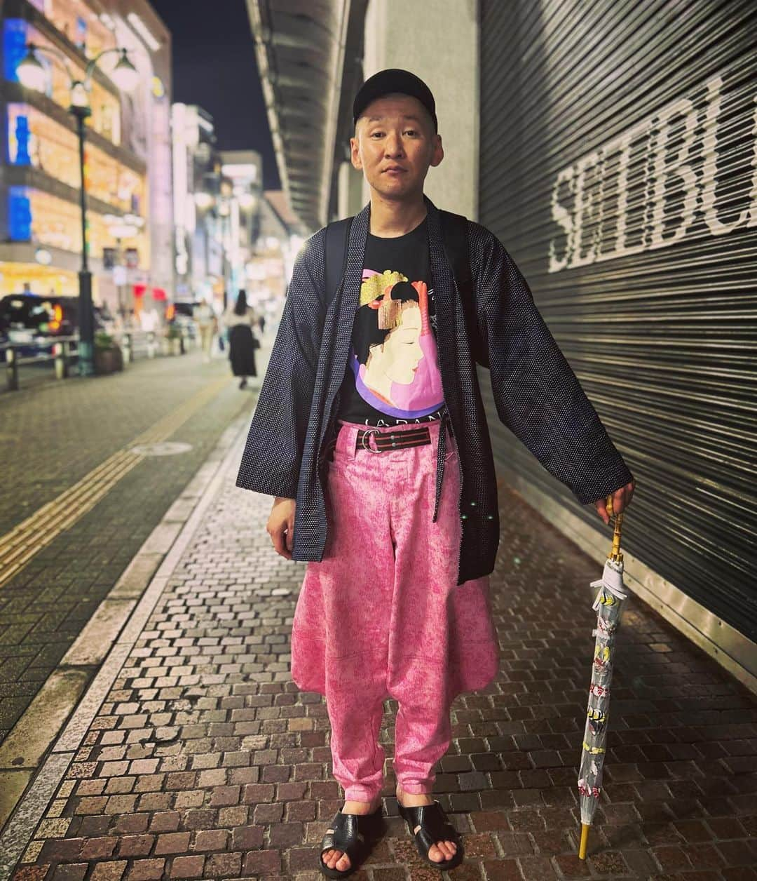 市川刺身さんのインスタグラム写真 - (市川刺身Instagram)「今日の服装。 ニューラジオ収録からネタ作り無限大でライブ。  家の中は暑かったけど出たら雨で寒くて舞妓さんのTシャツに宮田織物の羽織を慌ててチョイス。 ピンクのニッカで迷子でも見つけやすく。 PIKOのベルトで締め上げて。 無駄づくりの黒帽子に黒の便所サンダルmont-bellのメッシュリュック雨が上がって手には食べ物柄の傘。  明日は北九州でライブ。 確実な5時起きが必要であります。 6/12にGAGさんとの『つどい』 6/17に新ネタワンマンライブ『ダイヤ』 6/18『市川刺身のお造りライブ』 オマケに宿題も出始めてヤバめ。 やるしかない。 皆様是非観にきてください。 まずは明日の5時起きを考えながら西武デパートの脇で携帯置いて撮らせてもらいました。 金曜渋谷は人通り多すぎ。 人通りありがとう。  #今日着た服 #ファッション #古着 #ニッカ #舞妓 #カニチャーハン #食べました #早起き怖い」6月9日 20時52分 - soitsudoitsu