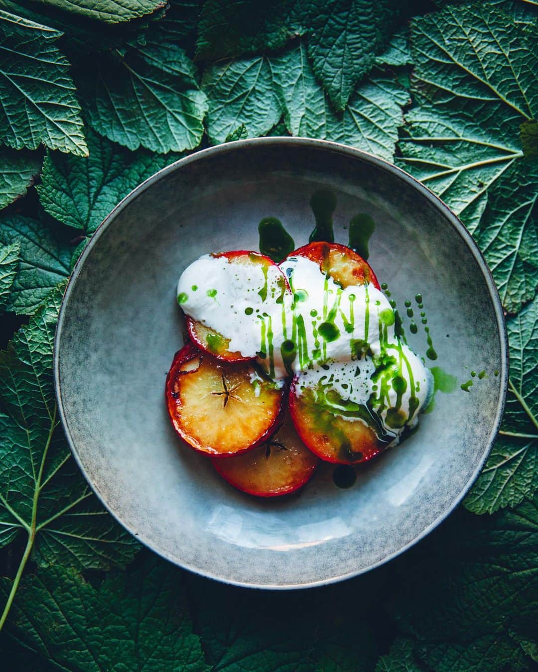 Linda Lomelinoのインスタグラム：「Caramellized apples with whipped cream and oil made from black currant leaves. Absolutely magical ✨Probably my favorite photo from @myfeldt’s new book ’Det växer saft och sylt överallt’. And as always with us two, completely improvised 🌱💚 #detväxersaftochsyltöverallt」