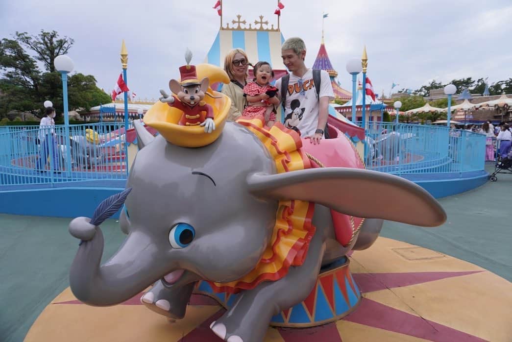 のインスタグラム：「🪄🏰🐘🌏🫏🚗🃏  ダンボは見たことないけどこのフォトスポットは すごく楽しそうで降りる時降りたくないって泣いた😂  ランドはベージュのミッキー、 妹と私は色違いで私がミッキー妹がミニーのTシャツ。 嶋津くんとジージもミッキーTという装い揃えにしました。 そう言うこともなかなかしてこなかったんだけど 子供いるとせっかくだしーってやりがち。😄  イーヨーがモヒカンの強面に見えたみたいでギャン泣き🫏💦  シーもランドもキッズプレートあるレストラン多いけれど 内容は大して変わらないので昼も夜も食べさせるなら ベビーフードとか茹で野菜とか持参した方がいいです。  マジカルミュージックワールドを見たのだけど 音の大きさに慄いた😂と思ったらアースラーに襲われる 1番怖くてうるさいとこで寝たちゃん👧💤 それぞれのキャラクターを視界を遮られることなく じっくりみることができて、外のパレードもいいんだけど こうして落ち着いて見ることができるショーいいなぁと思いました。  美女と野獣は怖がっているシーンもあったけれど ダンスの時は体を揺らして笑顔を見せていました。 ホーンテッドマンションはダメでした😨去年は寝てたね。 去年とはまた違い一緒に色々乗れるようになって楽しかったし 反応も変わっていて面白かったです。  ２日目は流石に大人も疲れもあるしで夕方で夢から帰りました。  しばらく姪っ子ファミリーとテーマパークとか 行けそうにないのでいい思い出になった２日間でした。」