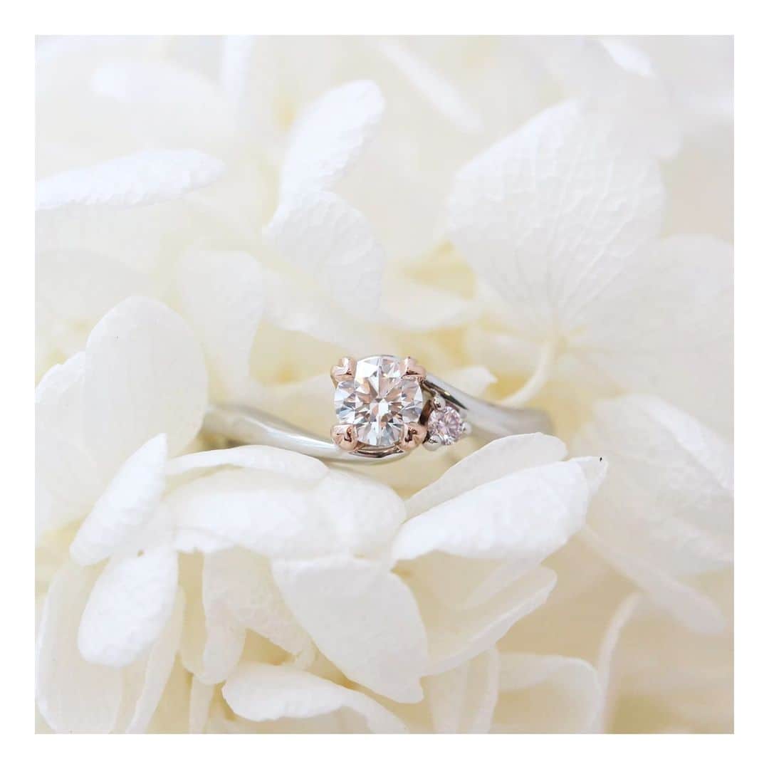 ith / イズ オーダメイド結婚指輪さんのインスタグラム写真 - (ith / イズ オーダメイド結婚指輪Instagram)「ダイヤを留める爪はピンクゴールドで、 サイドにはピンクダイヤモンドを。  爪の形はよく見るとハート型で4本。 四つ葉のクローバーをイメージして デザインされています。  指輪の名前は《フォルトゥナ》。 幸運の女神が由来です。  一生に一度の婚約指輪選びだからこそ、 とびきり甘くて美しいデザインを 選んでみませんか？  ▽ 指輪について 婚約指輪：フォルトゥナ Pt950/K18PG/0.2ct〜：338,000円〜  お問い合わせコード：22067  *********************************** ⧉ ith 公式WEB  @ith_marriage アカウントTOPへ 　 ☞ プロフィールURLをタップ  ⧉ 公式ハッシュタグ   ☞ #イズマリッジ   ⧉ 暮らしに寄り添うジュエリー  ith online store ☞  @ith_jewelry   ***********************************  #大宮 #ピンクゴールド #プラチナ  #婚約指輪 #エンゲージリング #カスタマイズ #オーダーメイド #オーダーメイドリング #手仕事 #結婚指輪オーダー #アトリエ #ピンクダイヤモンド  #ダイヤモンド #結婚指輪探し #結婚指輪選び #指輪選び #指輪探し #結婚準備 #婚約 #プロポーズ #プレ花嫁  #花嫁準備 #2023夏婚 #2023秋婚  #2023冬婚 #2024春婚 #職人」6月11日 21時40分 - ith_marriage