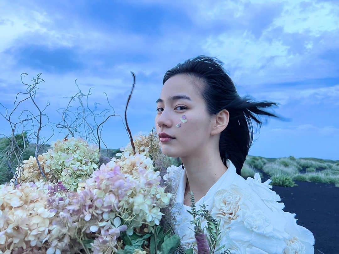 のインスタグラム：「シンガーソングライター・ヒグチアイ @higuchiai.1128 さんに作詞作曲いただいた、「PURSUE」収録の新曲「荒野に立つ」のMV公開を無事に発表出来ました。  私にとってとても特別な楽曲。 どんどんこの曲への思い入れが募っていって、MVの監督、編集、出演に自ら手を挙げました。  私のやりたい事ぜんぶ詰め込んで、 大好きなお花屋さんと、 信頼しているスタッフの皆様と、 team non一同、 みんな集めて最高傑作作りました。 自然の壮大な仕掛けにも恵まれ、涙に張り付いたドライフラワーの花びらも、小さな奇跡も大きな奇跡も積み重ねた。 この興奮を分かちあいたいのです。 ぜひ見てください。  明日6月28日(水)21時から、YouTubeでプレミア公開です。 （のんも一緒に見るよ〜。今からそわそわと緊張🫨）  Styling: @izumimachino Hair&Make up: Shie Kanno  #のんPURSUE #荒野に立つ」