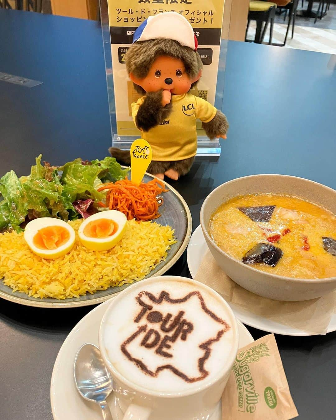 J SPORTSのインスタグラム：「ジョーヌなカレーとツールカフェラテ😋  レジ横で今年のコースマップと見どころを紹介したチラシと「サイクルビレッジ」のステッカーを置いていますので、こちらはご自由にお取り下さい！  https://www.jsports.co.jp/cycle/tour/cafe/  ◾️サイクルビレッジ https://www.jsports.co.jp/cyclevillage/  #ツールカフェ  #ツールドフランス #TDF #jspocycle  #tourdefrance #モンチッチ #monchichi」