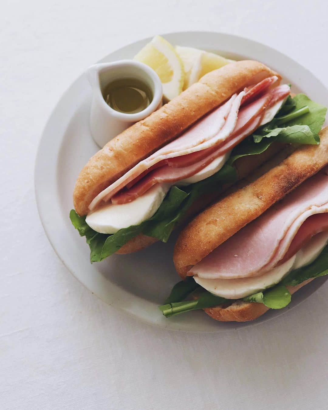 樋口正樹さんのインスタグラム写真 - (樋口正樹Instagram)「Sandwich . 今朝の朝食はサンドイッチ。 カスクートフランスを軽く トーストし切れ込みを開き、 中にオリーブオイルを回し かけ、岩塩と胡椒をふって、 ルッコラとモッツァレラと ロースハムをしっかり挟み、 あとかけオリーブオイルと レモン添えたおいしい一皿。 . パンはタカキベーカリーの。 @takaki_bakery_official  . . #サンドイッチ #ハムサンド #モッツァレラ #ルッコラ #サンドイッチ好き #カスクートフランス #パニーニ #タカキベーカリー #石窯パン #takakibakery #sandwich #panini #mozzarella #cassecroute #sandwichesofinstagram」6月13日 7時13分 - higuccini