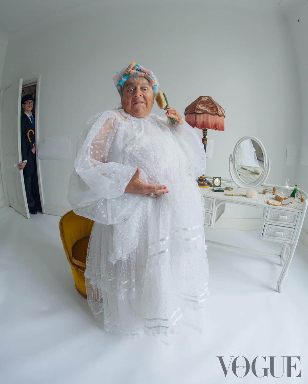 British Vogueさんのインスタグラム写真 - (British VogueInstagram)「“I’m still a bit of a child,” says Miriam Margolyes. “I can’t resist naughtiness.” In #BritishVogue’s July 2023 issue, the actor is at her very best – cheeky, wonderfully candid, and an absolute breath of fresh air. Click the link in bio to read the profile in full, and see the full story in the new issue, on newsstands Tuesday 20 June.  #MiriamMargolyes photographed by #TimWalker and styled by @KPhelan123, with hair by @AliPirzadeh, make-up by @BeaSweetBeauty, nails by @Simmy_NailsAndBeauty, set design by @MigsBento and production by @Zoe_Wassall at @GreatSouthernProductions, with thanks to @GeorgeN49.  [Image Description: Image one shows Miriam Margolyes, a white woman with silver hair sitting down at a table covered in white doily lace in an all-white room. She is shown from the waist up, and is naked except for pearl earrings, a pearl necklace and a blue cocktail ring. She is also wearing red nail varnish, a dark pink lipstick and has a small beauty spot drawn under the outer edge of her left eye. She is looking into the camera and smiling. In front of her sit two clear cake stands which hold piles of cherry Bakewell tarts, which cover her nipples. In between the stands is a floral saucer and teacup, with a small amount of tea inside.  Image two shows Miriam Margolyes, a white woman with silver hair, sitting in an all-white room. She is wearing a black headband, gold and pearl earrings, and a black coat. She has pink lipstick on, and is smiling into the camera.  Image three shows Miriam Margolyes, a white woman with silver hair standing in an all-white room. She is wearing a long black dress, a blue coat, a blue cocktail ring, pearl earrings, a pearl necklace, and red shoes which match her red nail varnish and red lipstick. She is looking just off camera and smiling, and in her right hand is a card with the number “3” on it. On the floor to her right is a black hanger, a red hat, red shoes, a black hat with a white bow, a houndstooth coat and cards with the numbers “1”, “7” and “9” on it.  Continued in pinned comments.]」6月14日 0時15分 - britishvogue