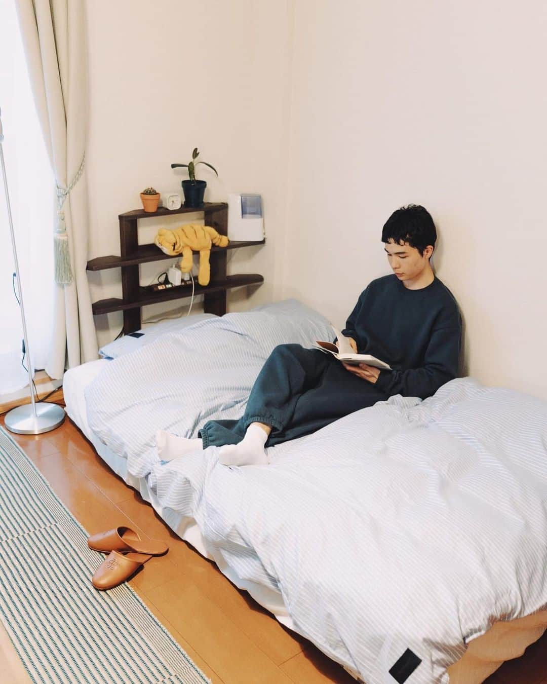 メンズノンノさんのインスタグラム写真 - (メンズノンノInstagram)「メルカリを駆使して低予算で作る、カルチャーを感じさせるワンルーム！  【おしゃれ男子の部屋カタログ／Vol.5・学生 西村崇義さん】  「コロナ禍以降、大学の授業や課題はリモートでこなすことが多くなり、それに伴って家で過ごす時間も増えました。だから自分が落ち着ける空間として、よりいっそうインテリアにこだわるようになったんです。アウトドアが趣味の僕は自然が好きなので、家具はウッドを使ったものがほとんど。そこにレコードやポスターなど、好きなカルチャーの要素を足していくことで、モダンかつ、遊び心のある部屋に見せています」  ■Desk レコードやポスター、雑誌などを壁にかけ、壁面の余白を埋めることで、デスク周りの雰囲気がぐっと増す！　好きなカルチャーに囲まれたデスクスペースだからこそ、作業に没頭できるという。  ■Living ・レコードプレーヤーのそばにおいた花は、近くから見ると実はレゴ！　陶器のフラワーベースに入れてリアルを追求しつつ、遊び心を感じさせてくれる。  ・限られたスペースを有効活用するために、あえてソファではなく、イデーのクッションをローテーブルのそばに。圧迫感のないフォルムで部屋が広く見える！  ■Bed リビングスペースと地続きのベッドは、低いものを選んで空間に奥行きを出せるように。ローテーブルのすぐそばにあるからこそ、ソファのようにくつろぎのスペースとして活用することも可能になっている。  詳細はメンズノンノウェブをチェック！ @mensnonnojp  Photos:Norito Ohazama  #メンズノンノ #mensnonno #メンズノンノウェブ #mensnonnoweb #一人暮らしインテリア #ワンルームインテリア #収納アイデア #勉強部屋」6月13日 18時42分 - mensnonnojp