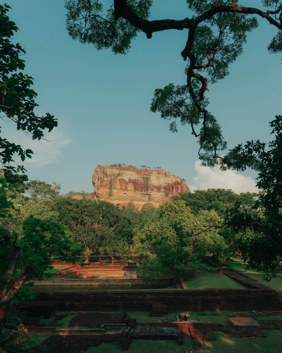 Putri Anindyaのインスタグラム：「The ancient rock fortress Sigiriya //   Sigiriya or Sinhagiri is a massive landmark at the middle of Sri Lanka. I went there at the sunset time but didn’t get to the top because I was kinda afraid to go up and had to go down when it’s dark. There are approx 1200 steps of stairs to go to the top. I climbed until The last stairs before the top as you can see on the 6th slide. It looks like a lion’s gate.   The name of this place is derived from this structure; Sīnhāgiri, the Lion Rock (an etymology similar to Sinhapura, the Sanskrit name of Singapore, the Lion City).  It was used as a Buddhist monastery until the 14th century. Sigiriya today is a UNESCO listed World Heritage Site. It is one of the best preserved examples of ancient urban planning.   Truly one of the best ancient landmark I’ve seen in my life. I felt like Short Round of Dr Jones at that moment lmao.」