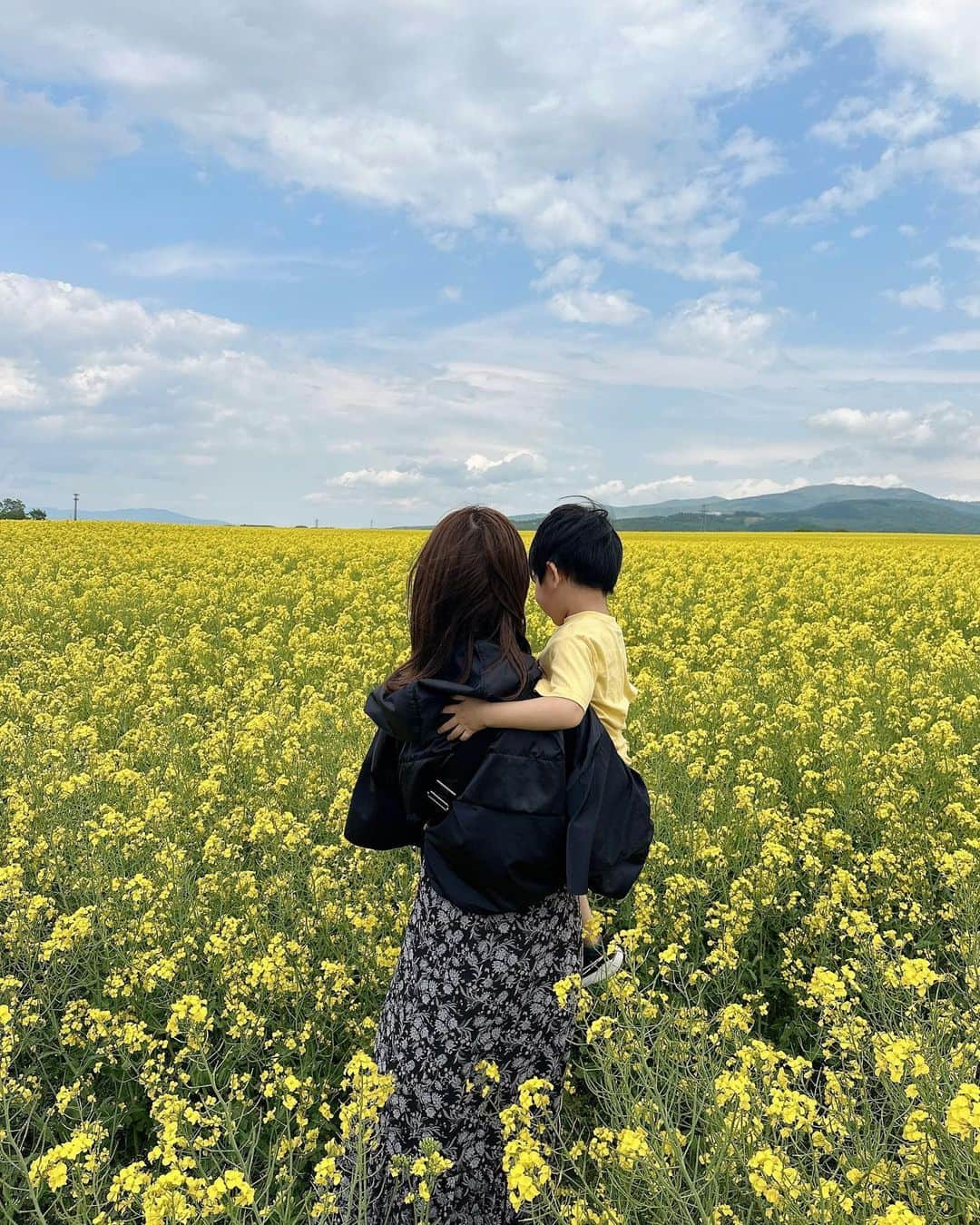 蒼川愛のインスタグラム：「北海道の想い出🌼*  たきかわ菜の花まつりで見た一面に広がる菜の花畑が本当に綺麗だったな〜 あいにくのくもり空と強風だったけど、普段見られない景色にとっても癒されました😌  作付面積は日本一で、180ヘクタールもあるらしい、、！(なんと東京ドーム40個分🙄)  こんなに広い土地いっぱいに綺麗な菜の花を咲かせてくれた高見農産さんに感謝だなぁと思いました🌼 来年もまた行けますように🫶🏻   #たきかわ菜の花まつり #菜の花畑 #北海道お出かけ #子連れ旅行 #北海道 #夏のお出かけ #高見農産 #pr」