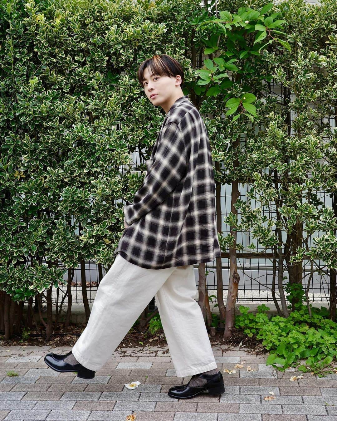 工藤大輝のインスタグラム：「梅雨時の注意。  スラックスのセンタークリースが消える。 濡れた状態で座ったりするとシワ酷い。 ホワイト系、泥水跳ねっ返り確実。  そして少しでも晴れた時鬱憤を晴らそうと白選びがち。  #comoli のレーヨンチェックシャツ。 皺になろうと汚れようとそれが味になるのがCOMOLIだと勝手に思ってるので、ガシガシ着る。洗濯もする。ガバッと大きめに着たかったのでサイズ４。絶妙な配色。インナーのTシャツも同じくCOMOLIです。  パンツは @farah_japan のワンタックワイドデニム。 去年リブランディングされた歴史あるワークブランド。 なので形は今っぽく、そしてお手頃。 アイボリーの色味、ルーズ過ぎないシルエット、そしてコスパの良さ。白系のパンツはどうやっても汚れるのでコスパ重視。 @cliche.jp の木下さんがまだ1LDKにいた頃、辞める手前ギリギリに購入させてもらった物。  シューズはまたも @leyuccas です。 夏に向けて購入したストラップタイプを初おろし。 こちらは大阪の @wunder__official にて自分サイズを見つけられたので躊躇せずいきました。育てます。  #comoli #farah_japan #leyuccas」