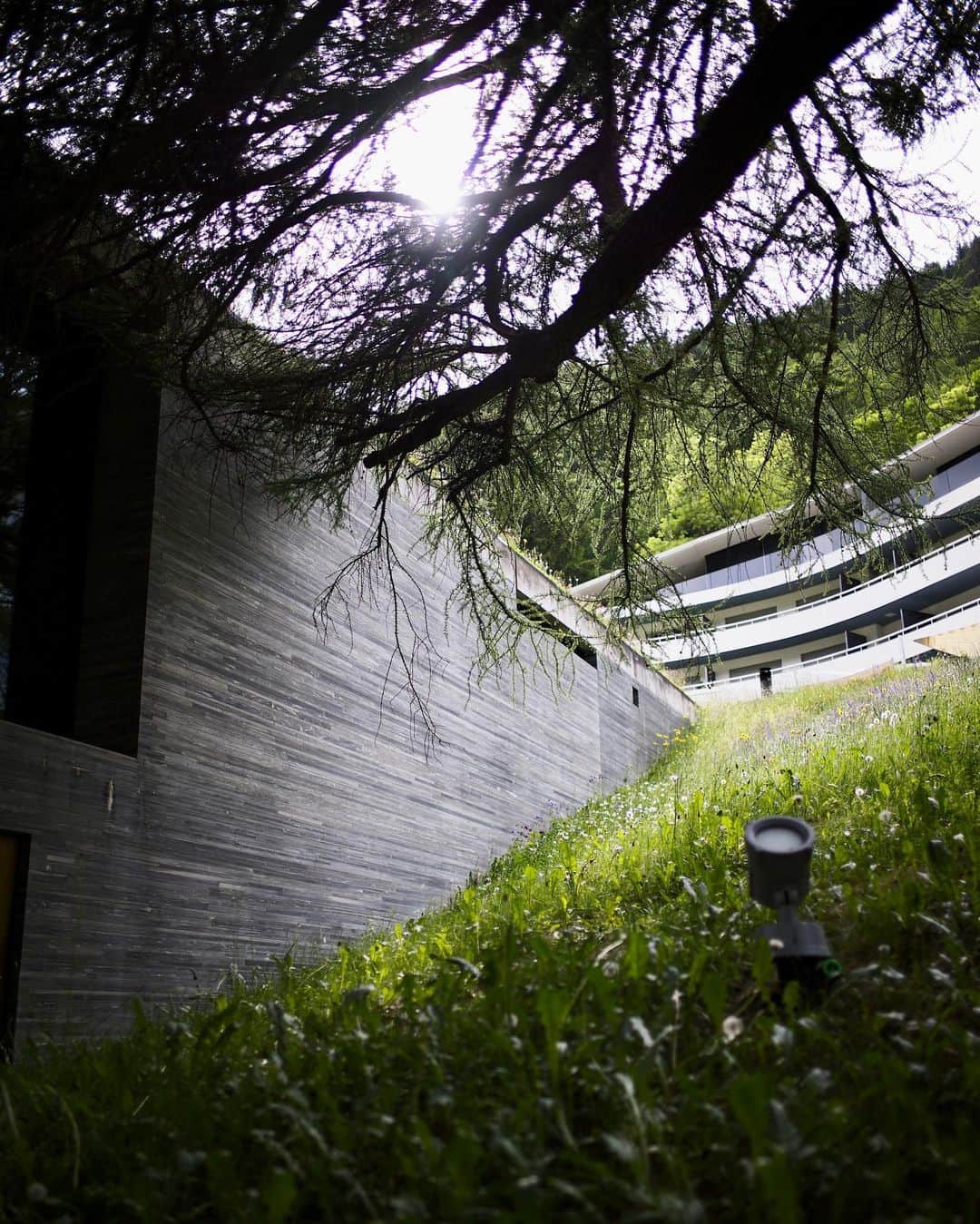 吉田拓巳さんのインスタグラム写真 - (吉田拓巳Instagram)「念願の建築家ピーター・ズントーの最高傑作と言われている温泉施設Therme Valsへ。 ずっと行きたかったけどなかなかこの付近に近付くこともないので、今回近いのか近くないのか、、、分からないけど。笑 スイスのバーゼルまで来たので、車で片道3時間かけて温泉だけ入りに行ってきました。とにかく美しい。 良い例えが見つからないけど、最上級の日本でいうスーパー銭湯のような。 温泉はもちろんだけど、水風呂からお花のお風呂、瞑想部屋まで。 その地元の石を使って創り上げているところもめちゃくちゃ良い。光の入りかたも美しく最高体験でした。 次回は泊まりで来たいです。（スパ内は写真が撮れないので、外観だけ。）  @7132hotel   #ThermeVals #PeterZumthor  #7132HOTEL」6月14日 15時23分 - tkmivj