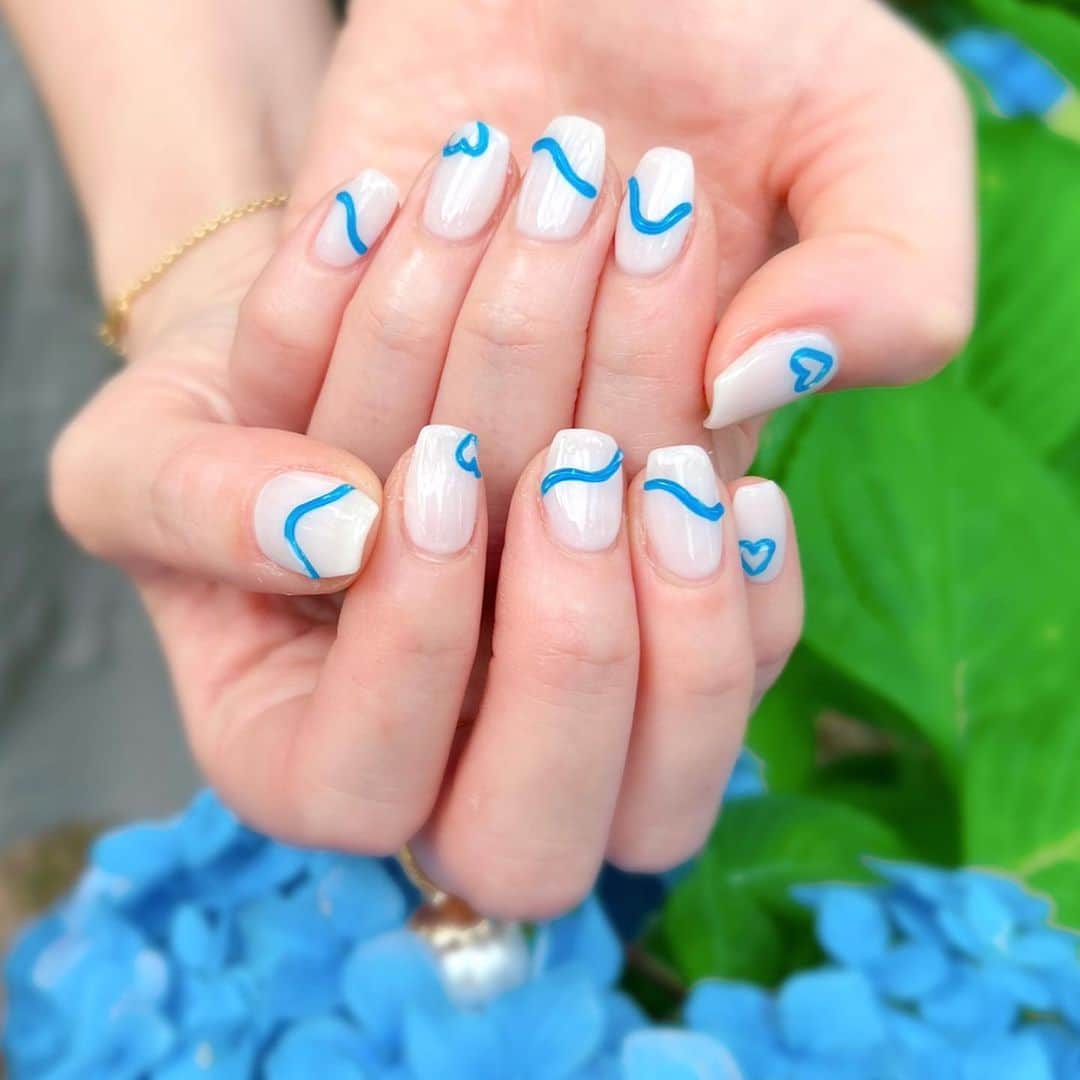 中島彩のインスタグラム：「Newnailは ブルーでぷっくりデザイン💙  スクエアにちゅるんとしたホワイトベース、 鮮やかなブルーのアートがお気に入り💙💙  鮮やかな紫陽花と一緒に👦が写真撮ってくれた🫶🏻💙  @silkderiver  @_silk.kaori  #ぷっくりネイル  #うねうねネイル #ブルーネイル  #韓国ネイル #スクエアネイル #元町ネイルサロン  #シルクドリバー  #ネイルデザイン  #夏ネイル」