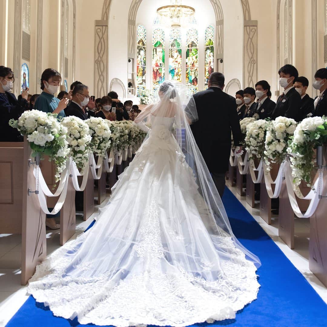 アニヴェルセル みなとみらい横浜 公式のインスタグラム：「ご結婚式の1日🤵🏻👰🏻‍♀️  〜ご入場〜 1歩が1歳と言われるバージンロード。ご新婦は大切な方と一緒に歩いて行きます。 沢山の思い出を振り返る大切な道です。  〜確認の儀〜 アニヴェルセル特別なセレモニー。 ご新婦の大切な方へ牧師から一言だけ伺いが入ります。ご新婦はきっとこの瞬間改めて大切に育ててもらったことを実感して頂けるそんなセレモニーです。  〜誓い〜 ゲストの前で、結婚の誓いをたてて頂きます。  〜家族の絆〜 ご退場前の特別なセレモニー。 ご家族でゆっくりとお話ができるそんな時間です。 挙式が結んだ後だからこそお伝えできる感謝のお気持ちを沢山お伝えください。  〜ご退場〜 沢山の祝福を受けながら未来の道へ進んで頂き、挙式は結びとなります💐  ﾟ･*:.｡. .｡.:*･゜ﾟ･*:.｡. .｡.:*･ﾟ･*:.｡. .｡.:*･゜  横浜 みなとみらいの結婚式場 #アニヴェルセルみなとみらい横浜  📌海や空のように「永遠に続く」という 　意味を持つロイヤルブルーのバージンロード  📌120年の歴史が刻まれた 　壮観なステンドグラスのチャペル  📌好みに合わせて選べる 　7つの貸切披露宴会場  @anniversaire_minatomirai  👆詳細はプロフィールURLの 　公式HPよりご覧いただけます✨  ﾟ･*:.｡. .｡.:*･゜ﾟ･*:.｡. .｡.:*･ﾟ･*:.｡. .｡.:*･゜  #アニヴェルセル #アニヴェルセルみなとみらい #結婚式場見学 #ブライダルフェア #結婚式準備 #式場見学 #花嫁準備 #結婚式準備 #横浜花嫁 #みなとみらい花嫁 #みなとみらいウェディング #みなとみらい婚 #みなとみらい結婚式 #横浜結婚式場 #プレ花嫁準備中 #プレ花嫁準備 #結婚式場 #2023花嫁 #2024花嫁 #結婚式#挙式#バージンロード#ロイヤルブルー#ウェディングドレス#タキシード#確認の儀#家族の絆」