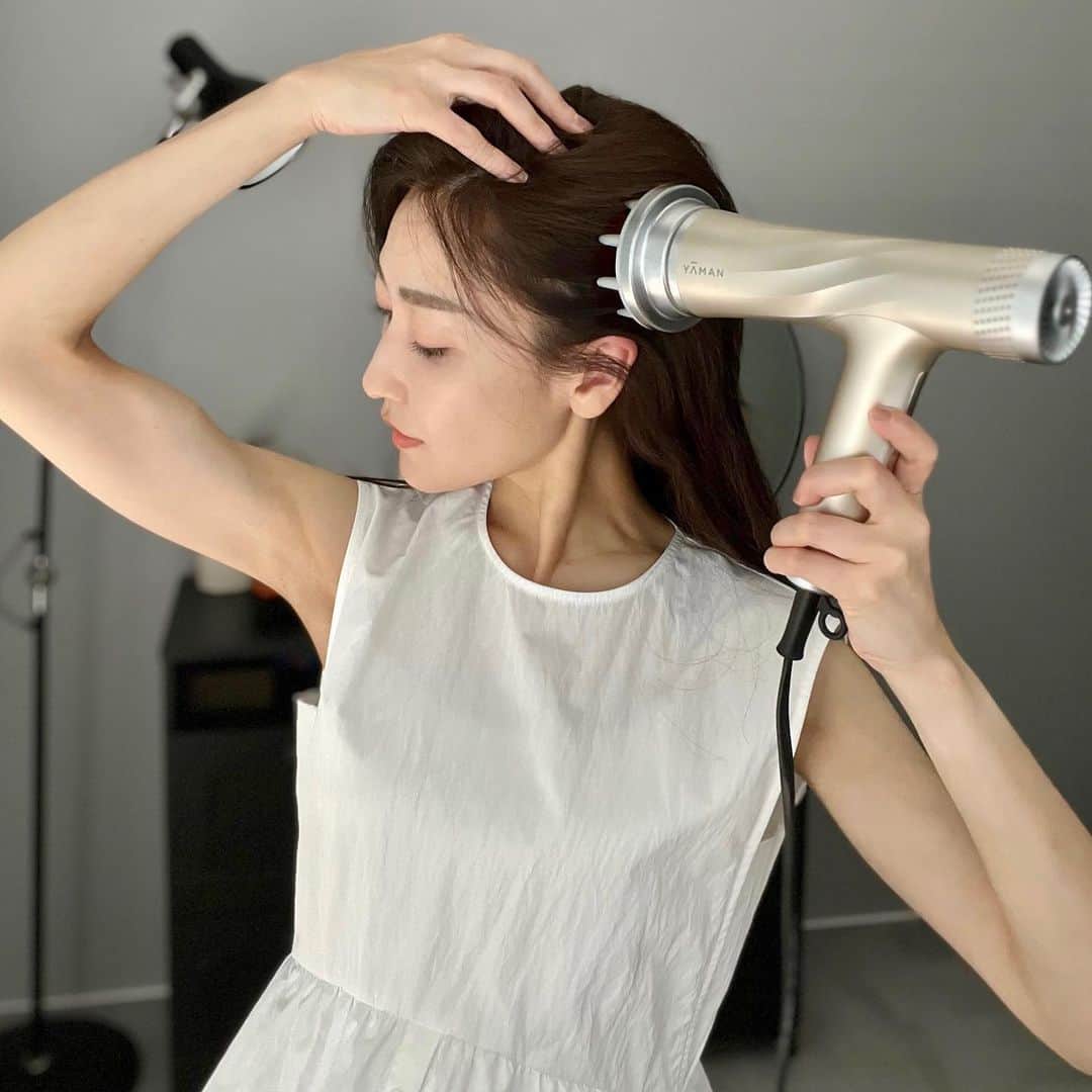 金子麻貴のインスタグラム：「ショートからエクステをつけて何が一番大変ってやっぱりヘアドライの時間が長くなった🤣 しかも束になるからなかなか乾くのが遅くて大変！  でもYA-MANのリフトドライヤーに変えたら時短が叶った✨ 低温なのにすぐ乾いて、うるおいとツヤをまとったヴェール髪に仕上がります✨ 根元が湿ってるとうねりの原因にもなるので梅雨の時期は特に根元をしっかり乾かすようにしています😌  そしてこのリフトドライヤー、HAIRモードの優れたヘアドライ機能はもちろん、FACEモードとSCALPモードでお肌と頭皮のケアが一緒にできる👏  FACEモードでイオン導入＆表情筋タッピングしてそのままSCALPモードにするとヘッドスパ＆根元ドライまで出来ちゃう！ 顔と頭皮の両方から筋肉にアプローチするから、顔がすっきりした気がする！  髪の毛を乾かす時間が短くなるだけじゃなく、浮いた時間でお肌と頭皮のケアまでできちゃうのはとっても嬉しいですよね❤️  毎日のドライヤー時間が美容習慣に変えられるから、忙しいママにも特におすすめ✨  #ヴェール髪#速乾#ドライヤー#リフトドライヤー#ヤーマン#pr」