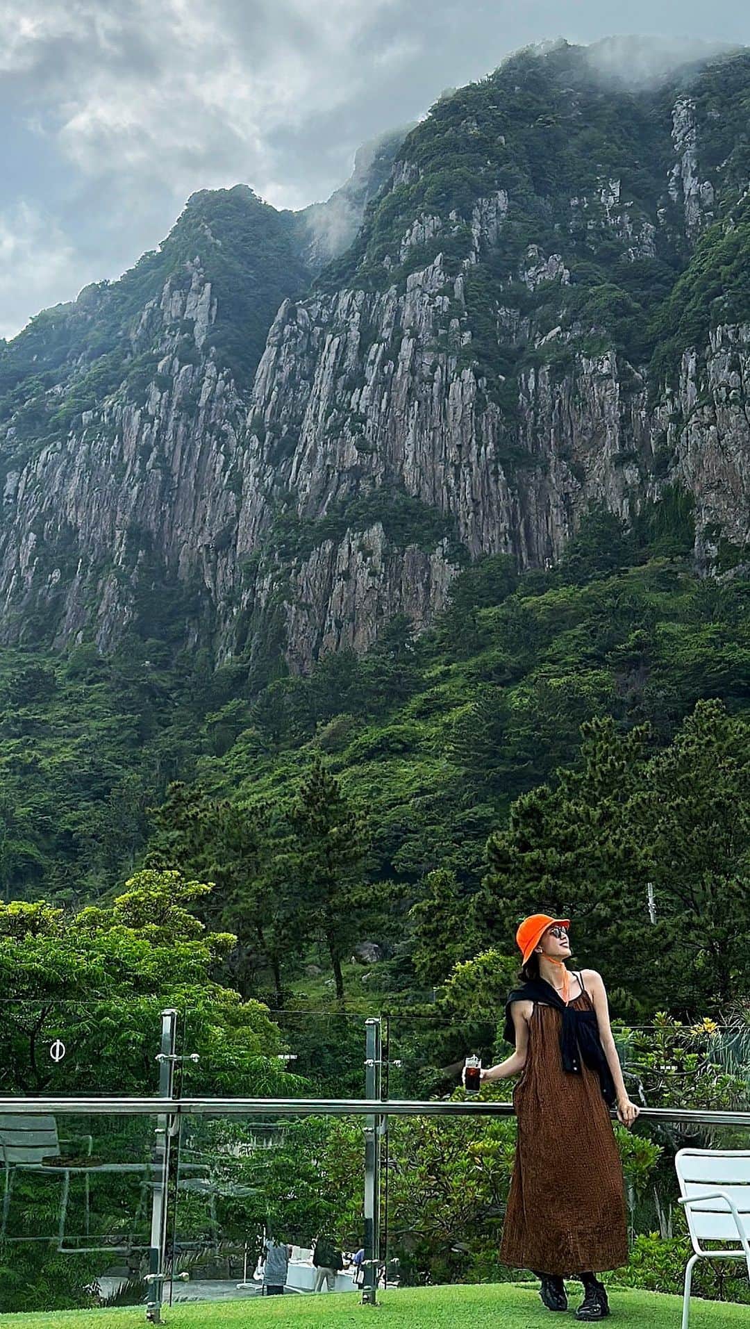 七野李冴のインスタグラム：「【Jeju Cafe☕️🍊】  チェジュ島のおすすめカフェ。 ※動画の最後に余計なダンス入ります  まずは空港から1時間半ほど離れた西帰浦エリアにある 壮大な岩を眺めながらくつろげるカフェ。 岩肌フェチにはたまらない絶景で Instagramで発見した時には絶対に行くと 心に決めたカフェは 行ってみたら期待を裏切らないすごいカフェだった！  カ…カフェですか…？  という敷地と建築。 広い店内には至る所にさまざまなくつろぎスペースがあり みんな思い思いにカフェタイムを過ごしている。  ビーチにもすぐにアクセスできて 西帰浦のこのエリアの観光地になっているくらい 車の出入りもすごかった！  なのに、不思議とウェイティングもなくみんなが座れる。 その秘密は席数なのか… 日本ならB&Bも併設してそうな規模のカフェだった！  絶景だからってぬるま湯に浸からないのが さすが韓国のカフェ！ メニューも豊富、ケーキもたくさん。 グッズも可愛くて欲しくなる。 コーヒーもおいしくって、ここはわざわざ来る価値あり！  韓国のカフェビジネスの凄さを思い知りました🤩  📍Jeju seogwipo ☕️ @jejuoneandonly  🇰🇷 #risastripinkorea   #jejuisland #jejutravel #jejudo #jejucafe #jeju_island #jejutrip #jejuislandkorea #jeju_korea #jejustagram #visitjeju #jejukorea #travelling  #seogwipo #seogwipocafe #jejudo_korea  #チェジュ #チェジュ島 #チェジュ島カフェ #チェジュ旅行 #韓国カフェ #海外旅行好き #カフェ旅 #おすすめカフェ #韓国旅行 #韓国情報 #海外旅行 #西帰浦  #제주 #제주여행」