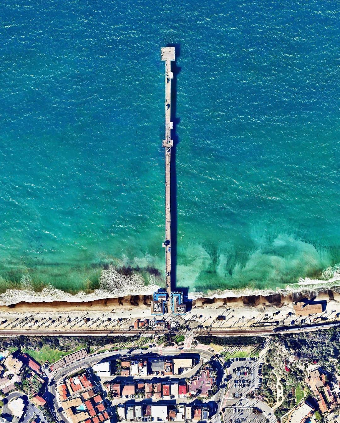 Daily Overviewさんのインスタグラム写真 - (Daily OverviewInstagram)「The San Clemente Pier in California extends 1,296 feet (395 meters) into the Pacific Ocean. Built in 1928, the boardwalk offers visitors an extensive vantage point to enjoy panoramic coastal views. San Clemente is situated roughly halfway between San Diego and Los Angeles and is home to roughly 65,000 residents.   Created by @benjaminrgrant Source imagery: @nearmap」6月17日 1時15分 - dailyoverview