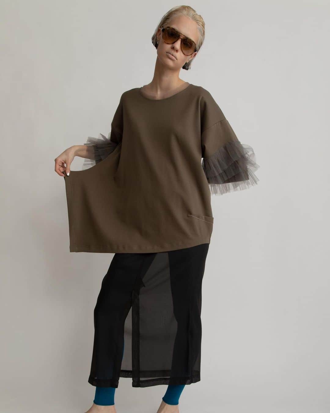 AULA AILAのインスタグラム：「【2023 HIGH SUMMER COLLECTION】  TULLE FRILL SLEEVE T-SHIRT COLOR KHAKI SIZE 0 ¥16,500  チュールを3段フリルにした、ビックシルエットのTシャツです。  ハリのある同色チュールがボリュームたっぷりで、目を引くデザイン。  見頃は透けないコットンスムースを使用し、右裾が長くスリット開き、左脇はコクーンシルエットのアシンメトリーなオーバーサイズ。  リラックス感とフェミニンなチュールフリルのミックス感が絶妙なアイテムです。  ✔️AULA AILA OFFICIAL WEB STOREにて HIGH SUMMER COLLECTIONアイテム展開中！」