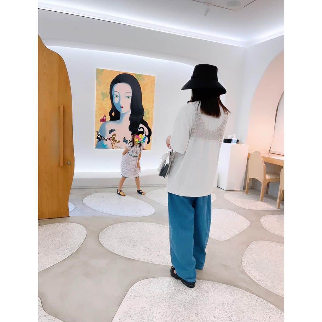 のインスタグラム：「ジャンコールの絵を見に3110NZ by LDH Kitchenへ。 女性の絵が3点。 昔の技法と現在の技法が混じり合ったようなタイムレスな魅力のある女性の瞳が美しいです。 肌の輪郭も紫からゴールドに変化していたり色使いにうっとりさせられました。  夏は汗かくからTシャツが最高 Tシャツとデニムにchikakisadaのアクリルブラを。  #ジャンコール　#NANZUKA #JangKoal　#育児　#子育て　#ママファッション #chikakisada #mamekurogouchi #mame」