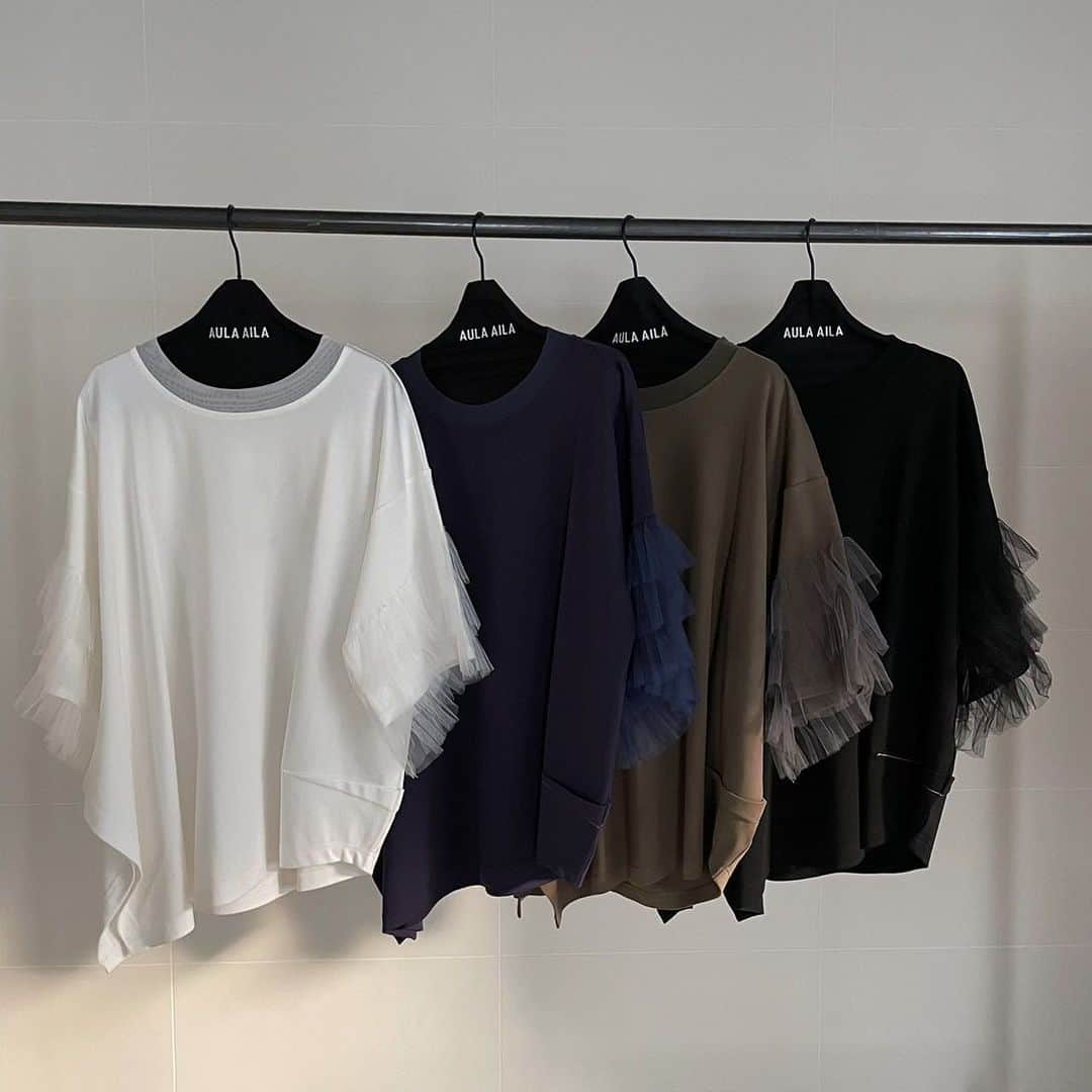 AULA AILAのインスタグラム：「【2023 HIGH SUMMER COLLECTION】  TULLE FRILL SLEEVE T-SHIRT COLOR OFF WHITE/NAVY/KHAKI/BLACK SIZE 0 ¥16,500  チュールを3段フリルにした、ビックシルエットのTシャツです。  ハリのある同色チュールがボリュームたっぷりで、目を引くデザイン。  見頃は透けないコットンスムースを使用し、右裾が長くスリット開き、左脇はコクーンシルエットのアシンメトリーなオーバーサイズ。  リラックス感とフェミニンなチュールフリルのミックス感が絶妙なアイテムです。  ✔️AULA AILA OFFICIAL WEB STOREにて HIGH SUMMER COLLECTIONアイテム展開中！」