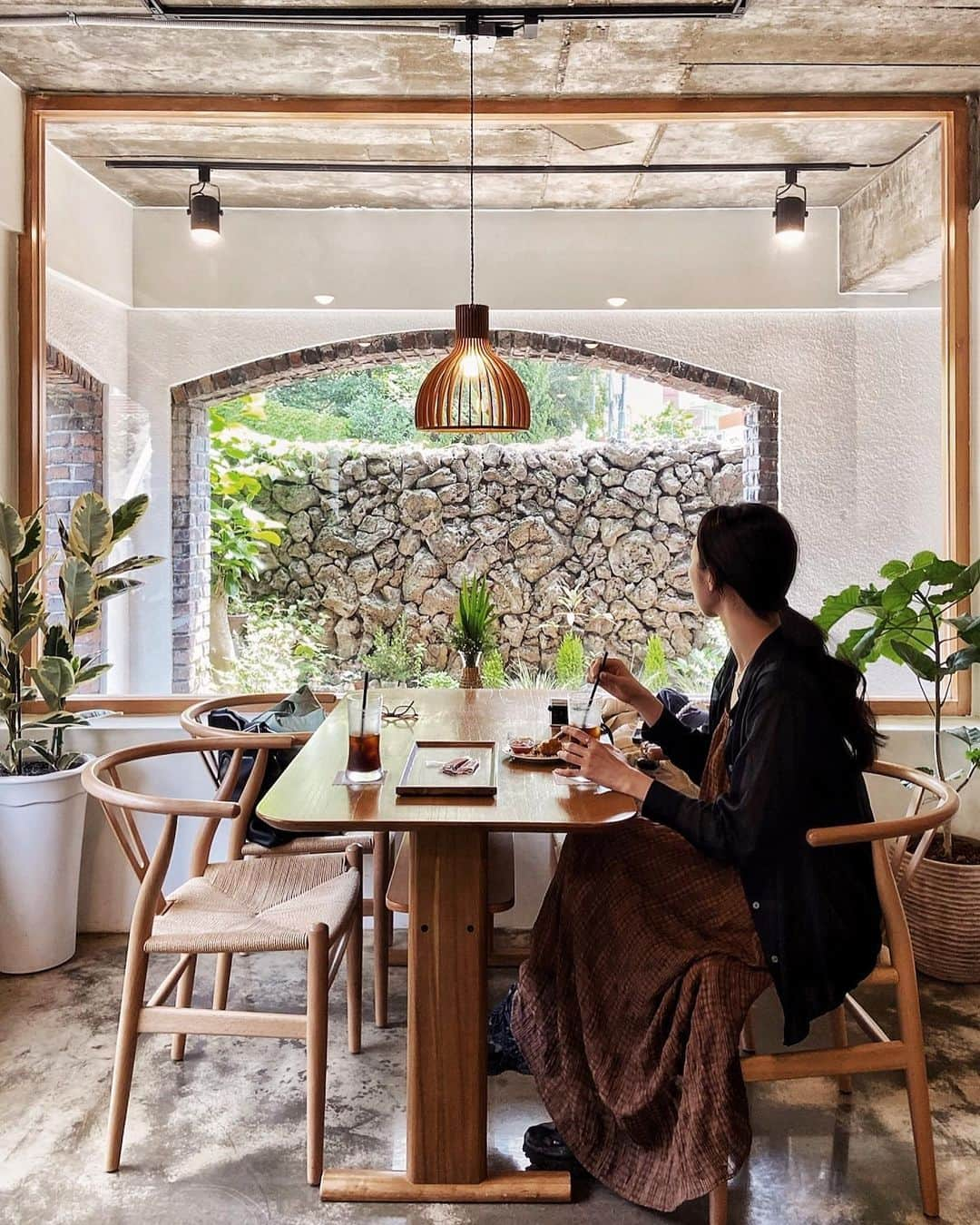 七野李冴のインスタグラム：「【Jeju Cafe☕️🍊】  チェジュ島のおすすめカフェ。  こちらは空港から近いチェジュ市内で見つけたお店。 昔ながらの石垣でできた建物の中にひっそりとある落ち着くインテリアのコチラは朝イチで行ったら空いてたよ！  窓の向こうに見えるアーチが可愛くって この席がお気に入り。 シンプルだけどレイヤーになってるデザインが、 抜かりないなぁ…さすがです！  つぶつぶしたスコーンも美味しかった🤭  📍Jeju  ☕️ @coffee.connects.us  🇰🇷 #risastripinkorea   #jejuisland #jejutravel #jejudo #jejucafe #jeju_island #jejutrip #jejuislandkorea #jeju_korea #jejustagram #visitjeju #jejudo_korea #travelfashion  #チェジュ #チェジュ島 #チェジュ島カフェ #チェジュ旅行 #韓国カフェ #海外旅行好き #カフェ旅 #おすすめカフェ #韓国旅行 #韓国情報 #海外旅行 #旅服  #제주 #제주여행」