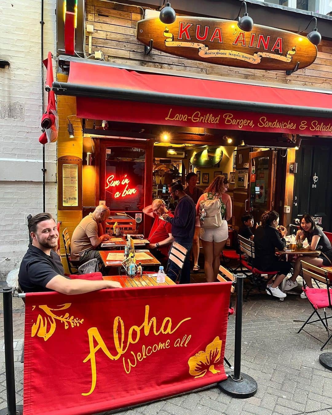 Kua 'Aina UKさんのインスタグラム写真 - (Kua 'Aina UKInstagram)「🌭 K U A A I N A (invite/pr) • I was kindly invited down to @kuaainauk restaurant near Carnaby Street, Soho to try their range of hot dogs. Guys this is such a cute little spot in a real buzzy part of London and it made such a lovely Friday night date night! You can see the pictures speak for themselves, the food was yummm 🤤  🏝 What did we order:   • Classic Hotdog - Pork or Beef Sausage with ketchup, mustard, fried onions & dill pickle. This was delish, we both loved the crispy onions 🧅 • Chicago Hotdog - Beef or Pork sausage with authentic neon green Chicago dog relish, sport peppers imported from the US, celery salt, mustard & white onion. This was our least fave but still good  • Chilli Cheese Hotdog - Beef or Pork sausage topped with house made chilli con carne, jalapeños and cheese sauce. Omg if you like a little kick and spice this is for you, this was very yummy and super filling!  • Fries - Crispy & delish • Homemade Slaw - Real good • Halloumi Fries - A little overcooked for us but liked the yoghurt & pomegranate with it  • Mango Daiquiris - These we’re blimming AMAZING, made perfectly 🥭   💛 From the moment we got there we felt welcome and service was very efficient. I loved the Hawaiian themed decor inside although we sat outside as was a sunny evening 🌞 Great atmosphere too was pretty busy they were fully booked!   🫶🏼 Thank you for having us @kuaainauk - I deffo recommend visiting and trying their scrumptious hotdogs ✨  #kuaaina #kuaàina #hawaiianrestaurant #hawaiianfood #chicagohotdog #chicagofood #hotdog #hotdogs #hotdoglovers #fries #halloumifries #coleslaw #mangodaiquiri #daiquiri #cocktails #soho #sohorestaurant #carnabystreet #londonfood #londonrestaurants #londonfoodies #foodblogger #foodlovers #foodporn #datenight」6月20日 1時29分 - kuaainauk