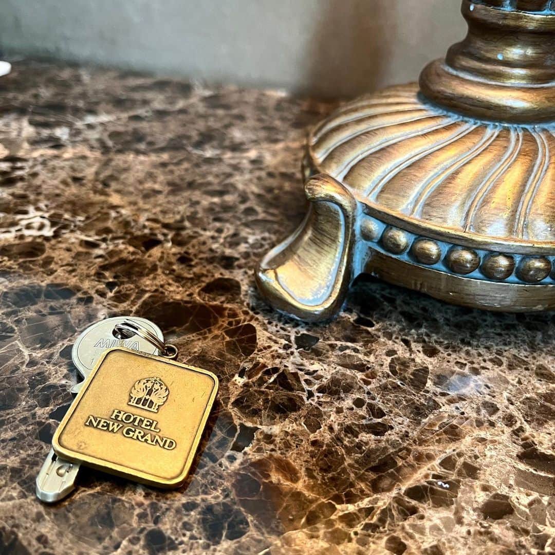【公式】ホテルニューグランドのインスタグラム：「＊ 真鍮製のキーホルダーが付いており、 使い続けることで燻したような深い色合いとなる 当ホテルのルームキー。 昔ながらの鍵からもクラシックホテルとしての 長い歴史を感じていただけます。   #ホテルニューグランド #横浜 #横浜ホテル #クラシックホテル #クラシックホテル巡り #ルームキー #ホテルルームキー #真鍮 #真鍮製 #客室 #ホテル客室 #本館 #タワー館 #横浜時間 #思い出 #ホカンス #横浜観光 #横浜ステイ #国内旅行 #家族旅行 #夏休み #旅行 #旅行記 #女子旅 #ホテル好き #フォトジェニック #hotelnewgrand #yokohama #trip #yokohamahotel」