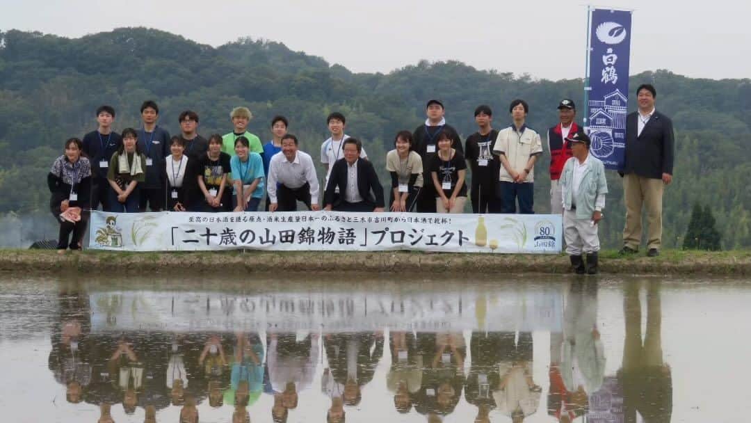 白鶴酒造株式会社のインスタグラム：「🌾🍶 ＼#二十歳の山田錦物語／ 6月18日（日）に兵庫県三木市吉川町で 県下の大学生が #山田錦 の「#田植え」を体験！  こちらのイベントは、 20歳を迎える兵庫県下の学生を対象に、 山田錦の栽培と酒造りを通じ、 村米制度の伝統を伝え、 兵庫県が日本一の生産量を誇る 山田錦と日本酒への関心を高めてもらう ことを目的として、 山田錦生産者とJA・行政が主催しています。 今年は、当社の村米地区の1つが このプロジェクトの圃場となるため、 当社が収穫したお米でのお酒造りに協力します。  当日は、「山田錦の館」で 酒米「山田錦」の歴史や酒造りに適した特長、 古くからの酒蔵との関わりについて 学んでからの田植えでした。 まっすぐ同じ量を植えるのが大変だったとの声もありましたが とても楽しそうに田植えをしてくださっていました。 灘五郷の近くに住んでいる方や 既に日本酒が好きな方など、 参加したきっかけは様々でしたが 次の収穫体験が楽しみです。  開会の挨拶では 吉川町山田錦村米部会の五百尾会長から 「農家と酒蔵は運命共同体」といったお言葉がありました。 また、三木市の仲田市長、みのり農業協同組合の神澤組合長からも コロナ禍の規制もなくなって今後への期待のお言葉ありました。 酒蔵としては、酒米農家さんと 共存共栄していけるように 一緒に頑張っていきたいと思います。  #白鶴 #hakutsuru #日本酒」