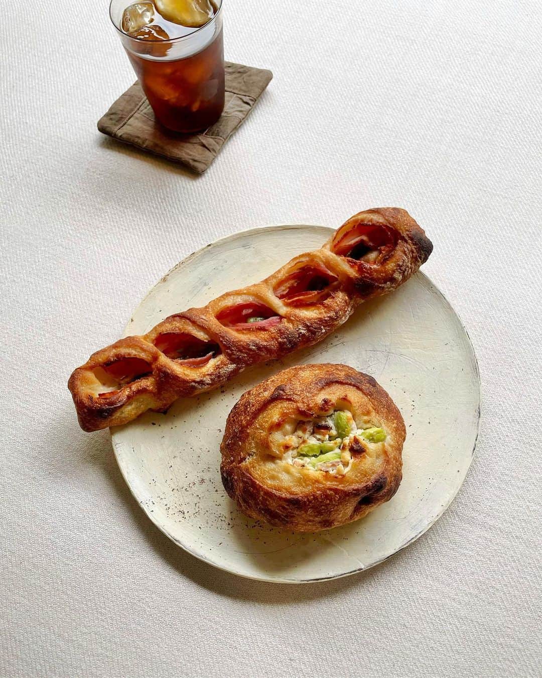 のインスタグラム：「⁡ ⁡ こんばんは。 只今onlineshopにて次回発送分のパンset、焼き菓子setを販売しています。 次回は21日（水）〜25日（日）の発送です。 ⁡ 写真の“ししとうとベーコンのエピ”はOPENからずっと焼いています。 お店では稲穂の形で焼いていましたが、発送の際に折れてしまう場合があった為、このような細長い形で焼いています。 ししとうがクセになるエピです。 ⁡ パンsetは久しぶりの2種類。 それぞれ少しずつmenuが違うので、 ゆっくりご検討ください。 ⁡ ⁡ ⁡ uneclefのパンset A 【menu】 ・ユヌカレ〜食パン〜（１斤）×１ ・レーズンとオレンジピール（半斤）×１ ・チョコのプティ（３個入り）×１ ・イングリッシュマフィン（２個入り）×１ ・フォカッチャ オリーブ ×１ ・ケールとデュカのリュスティック ×１ ・枝豆とクミン ×１ ・みょうがとベーコン ×１ ・ローステッドガラムマサラのブリオッシュ ×１ ⁡ ⁡ uneclefのパンset B 【menu】 ・ユヌカレ〜食パン〜（１斤）×１ ・レモンとセージ（半斤）×１ ・さやきレーズンのプティ（３個入り）×１ ・イングリッシュマフィン（２個入り）×１ ・フォカッチャ ドライトマト ×１ ・ケールとデュカのリュスティック ×１ ・そら豆とクリームチーズ ×１ ・ししとうとベーコンのエピ ×１ ・抹茶とホワイトチョコとクランベリー ×１ ⁡ ⁡ ⁡ onlineshopは、instagram TOPのリンクから お越しいただけます。 どうぞ、よろしくお願い致します。  @uneclef ⁡」