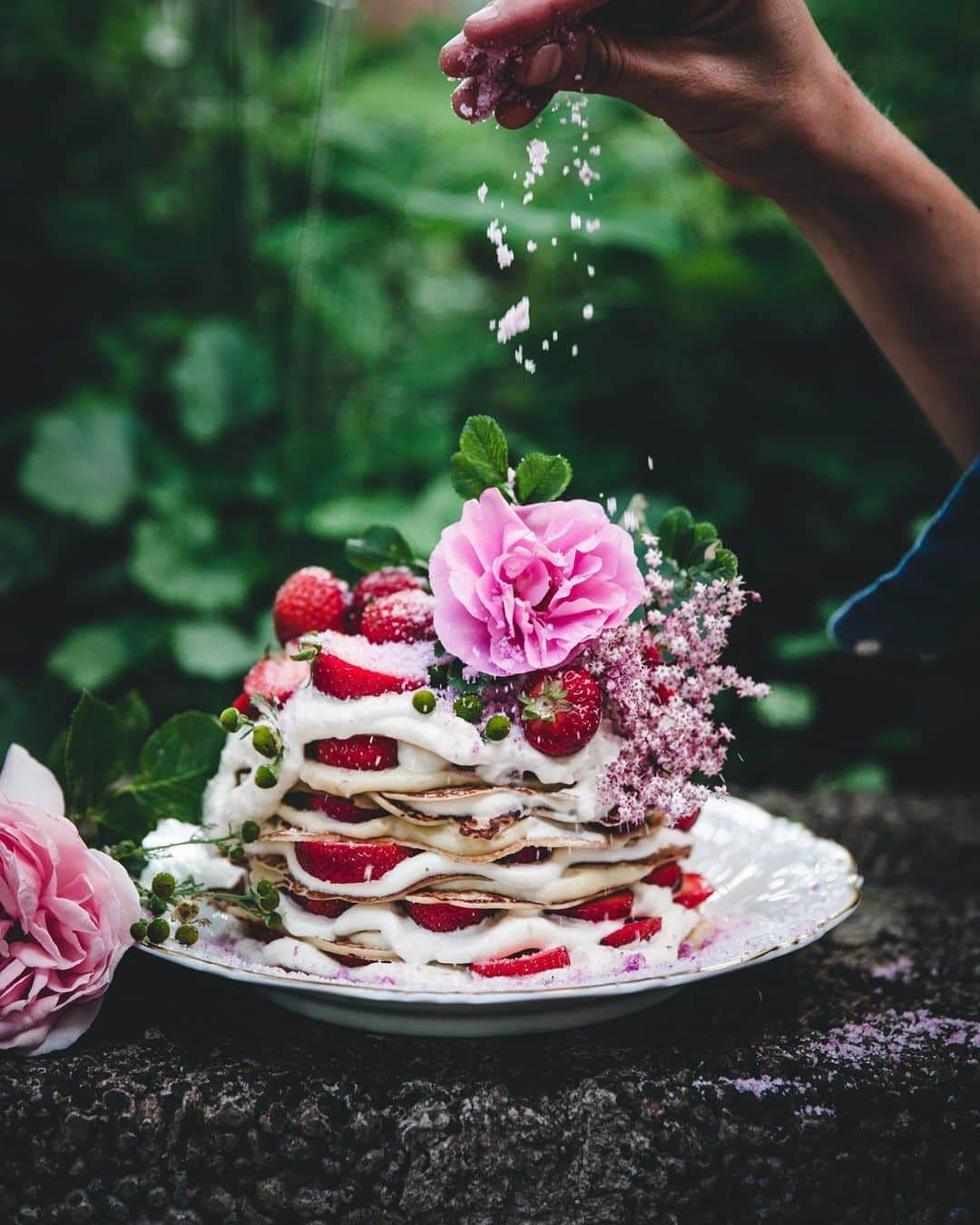 Linda Lomelinoのインスタグラム：「From @myfeldt.se second book ’Rullrån och tankebrus’, crêpe cake filled with chamomile cream and strawberries. Topped with rose sugar and pink elderflower 🌸 Perfect for midsummer.   #midsummer #midsummercake」