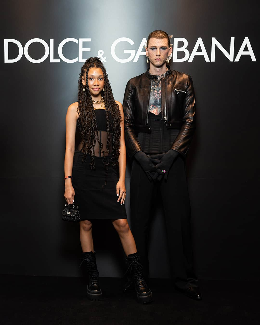 ドルチェ&ガッバーナさんのインスタグラム写真 - (ドルチェ&ガッバーナInstagram)「Wearing total #DolceGabbana looks in attendance of the #DGSS24 Men’s Fashion Show “Stile” were @machinegunkelly and Casie Colson Baker, @lukehemmings and @jasonfernandezbirchwood.    Machine Gun Kelly wore a black biker jacket, a black cummerbund, black wool tailored trousers, and black pointy boots, completing the look with #DGLogo earrings and a black necklace.    His daughter Casie wore a strapless cady black dress with mesh and boning details, styled with a black crystal mini #DGSicilybag, black laced up boots, golden chain necklace and pearl earrings.    Luke Hemmings wore a Portofino suit in cream tobacco pinstripes with a bowling cotton shirt from the Roma collection, and finally he accompanied the look with chestnut Ariosto loafers.    Jason Fernandez wore a handmade knitted tank top with coin shaped details from the Roma collection, along with a pair of wide white linen trousers and a square toe derby.    #DGCelebs」6月21日 22時00分 - dolcegabbana