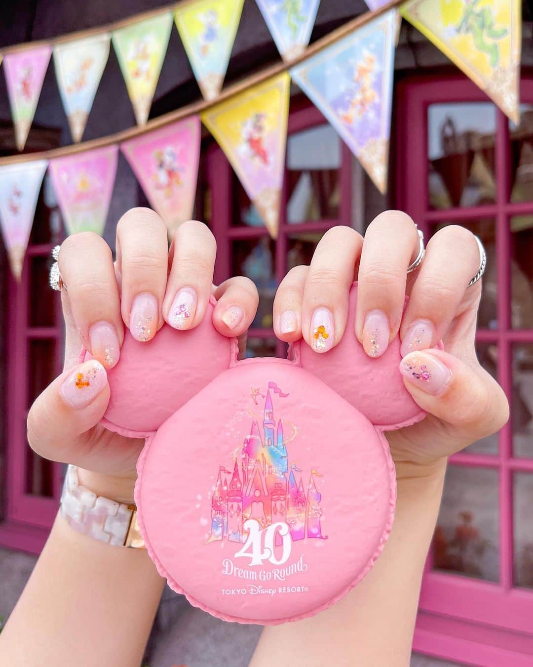 のインスタグラム：「＊  ＊  大人気の「ミッキーマカロン(ダブルベリー)」を握って、ネイルを撮影💅  今回は、40周年を意識したピンク＆オレンジのネイルです💓  ポイントは、隠れミッキー😁  陽の光に当たるとキラキラして綺麗でお気に入り〜💫  .  @atelierharuka_mhi  いつもありがとうございます🙏  .  ミッキーマカロンは、この間もレポしましたが…  甘酸っぱくて美味しいです🍓  なんと、早くも2店舗に縮小したみたいなので😱  近々購入予定の方はお気をつけて✋  .  ☑︎ミッキーマカロン(ダブルベリー)  単品 600円 スーベニアケース付き ＋1000円  販売店舗 ⚫︎ヒューイデューイルーイのグッドタイムカフェ(TDL) ⚫︎セバスチャンのカリプソキッチン(TDS)  販売期間 2023年6月13日〜2024年3月31日  ※スーベニアケースを付けたメニューは1回の会計でひとり1つまでオーダーできます。  .  #tokyodisneyresort #tokyodisneyland  #disneygram #disneylove #disney  #東京ディズニーリゾート #ディズニー #ディズニー女子 #ディズニー #ネイル #ディズニーネイル #ミッキーマカロン #東京ディズニーリゾート40周年」