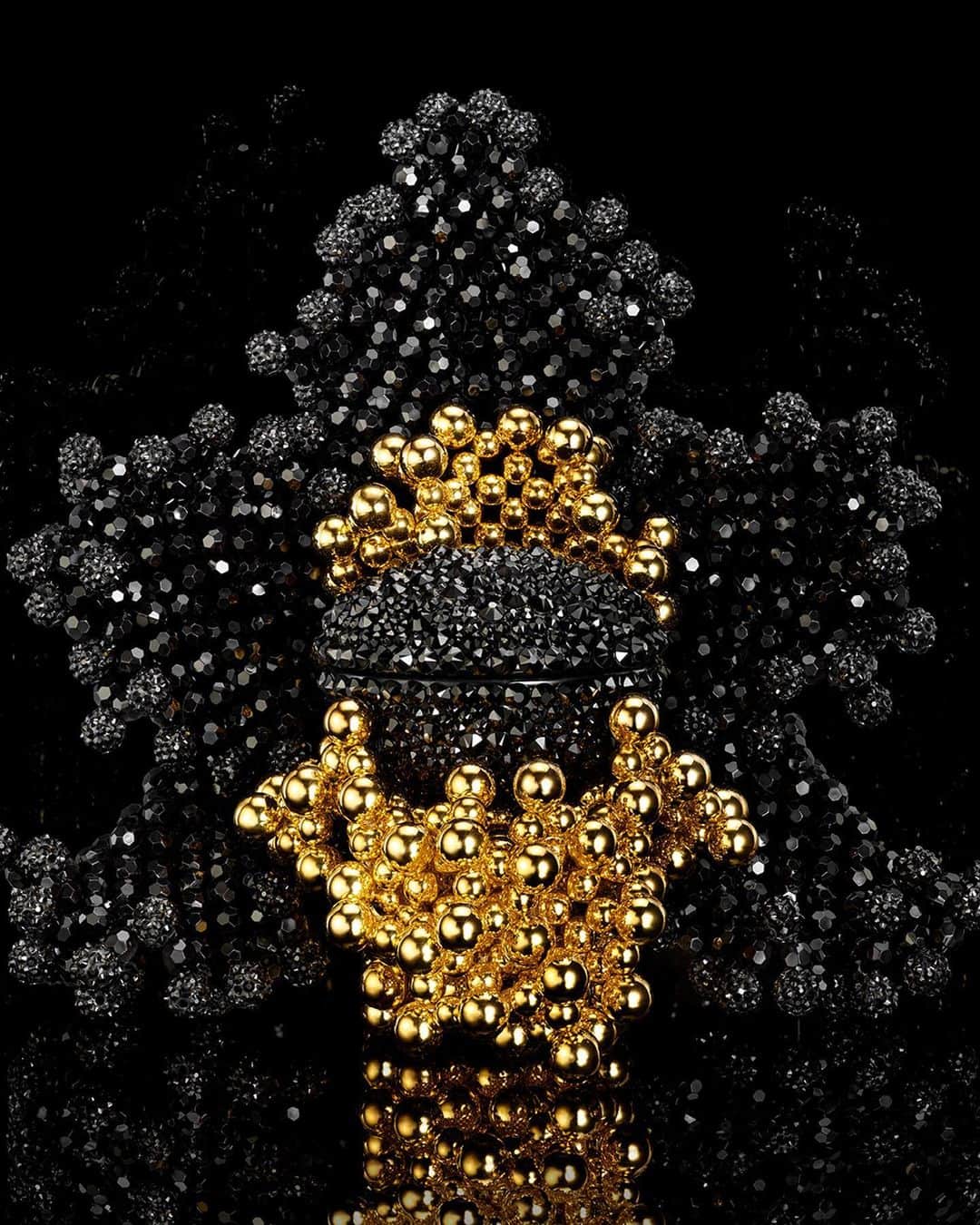 のインスタグラム：「Orchidée Impériale Black The Cream is transformed in a stunning Exceptional Piece by Kevin Germanier.​  The precious porcelain jar is embellished with black Swarovski crystals from former collections. As a counterpoint to the black of the outer petals, the heart of Kevin Germanier's couture flower blooms resplendent in radiant upcycled golden pearls, reflecting the artist's savoir-faire and commitment to offering a second life to forgotten elements.  @swarovski @kevingermanier #Guerlain #OrchidéeImpériale #ExceptionalPiece」
