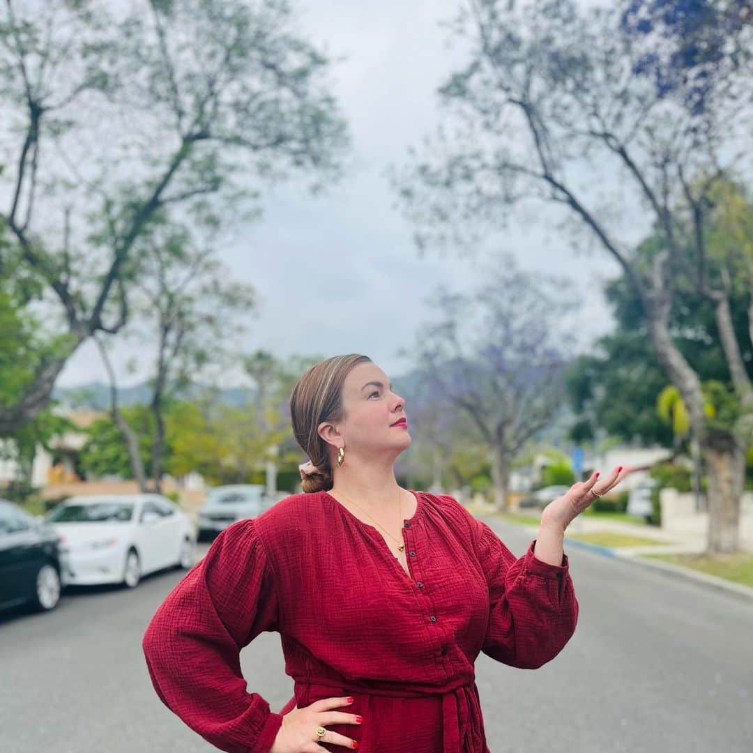 アンバー・タンブリンのインスタグラム：「Reframing our thoughts around gloomy weather—especially in the sunshine state of California—might just open up a door to help us find a new appreciation for it. Head to the link in my bio to read the essay and subscribe to our newsletter.  Pictured: Me in California recently, enjoying the early bloom of jacaranda trees under infamous gray skies.   📸 @DerrickBrownPoetry」