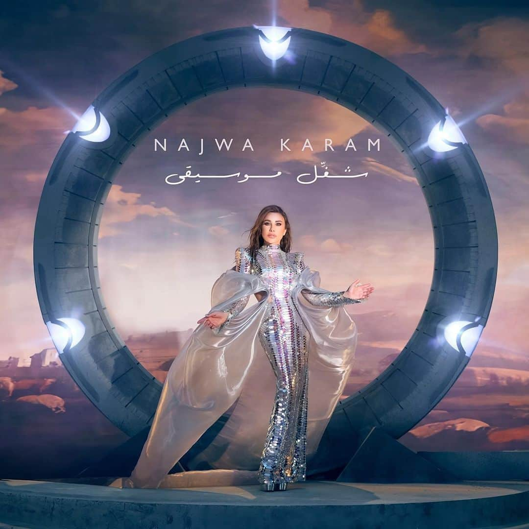 ジュリアンマクドナルドのインスタグラム：「The divine and elegant @Najwakaram debuted her new album #Karizma wearing a metallic aurora borealis lilac couture gown for her latest Music Video.  A serpent-inspired gown with laser cut plexi, overlayered with hand-dyed iridescent purple and transparent sequin, completed with hand metallic oil slick and cut wave sequins that create an intricate snake embellishment and finished with a signature statement shoulder.  Congratulations on all your success @Najwakaram 🤍」