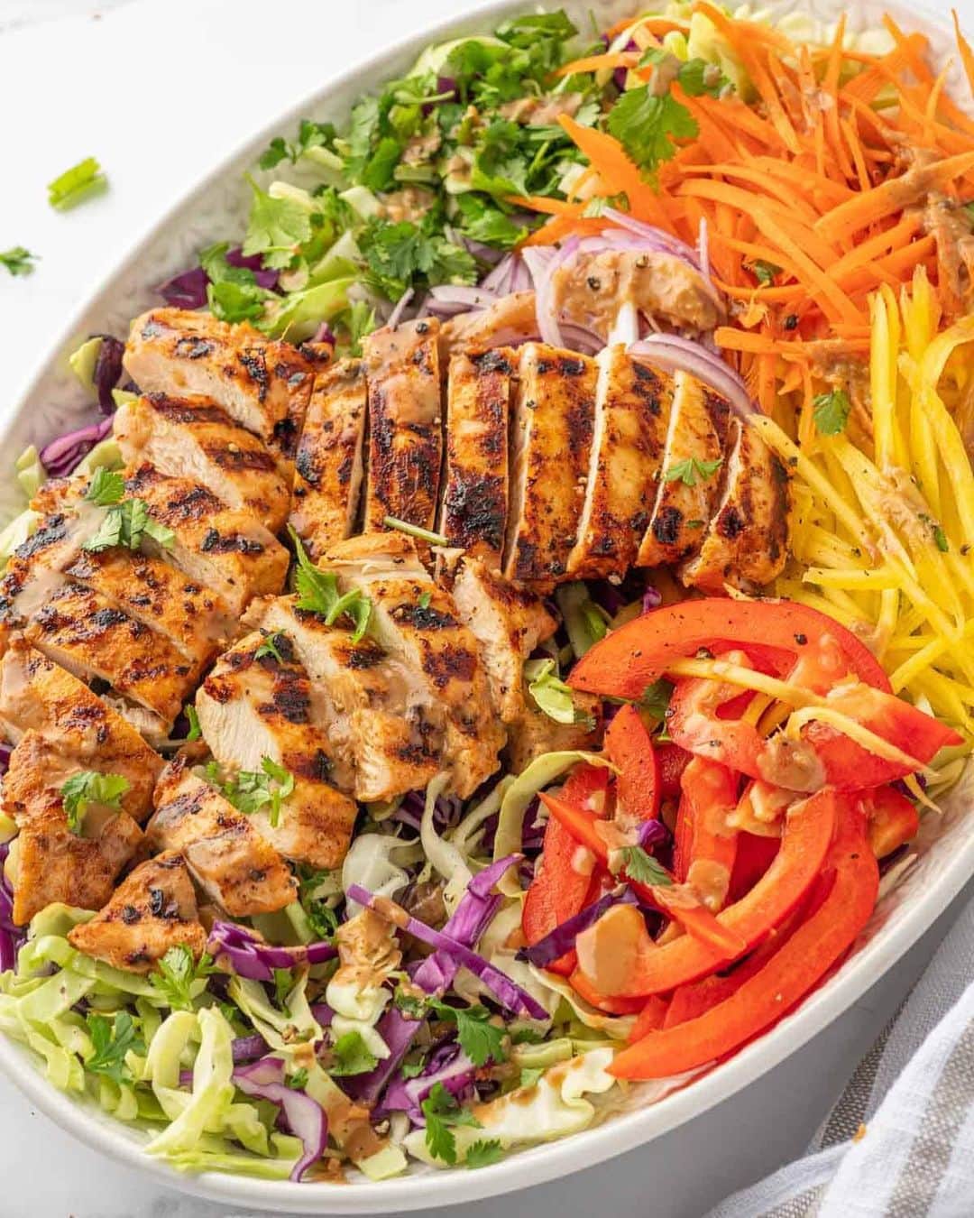 Easy Recipesのインスタグラム：「This Thai Mango Chicken Salad recipe features succulent grilled chicken paired with juicy mangoes, a medley of vibrant veggies, and a creamy, nutty dressing packed with authentic Thai flavors. You’ll love the delectable fusion of sweet, savory, and tangy goodness that awaits you with every forkful of this chicken salad with mango!  Recipe link in my bio @cookinwithmima  https://www.cookinwithmima.com/thai-chicken-mango-salad/」