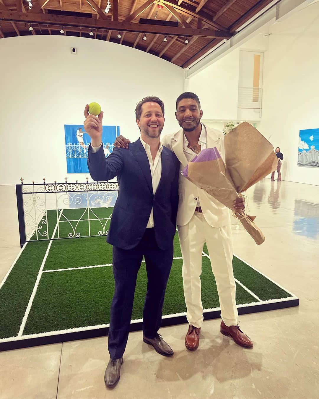 デレク・ブラスバーグのインスタグラム：「CAME TO L.A. TO CAUSE A RACQUET. 🎾 Congratulations to @honortitus, my king of the court, who’s new show “Advantage In” opened last night at @gagosian. Inspired by the gentility and tradition of tennis, the paintings are an ace display of humanity and nostalgia the sport. And yes, that’s a court in the middle of the installation. (Random fact: The tennis courts of my suburban Missouri high school were abandoned and finally condemned by the state, which is presumably why I grew up admiring the grace and elegance of the GOATs of the sport.) The night’s perfect final set: A midnight picnic on Merv Griffin’s tennis court in Beverly Hills. Well served, Honor! ❤️」