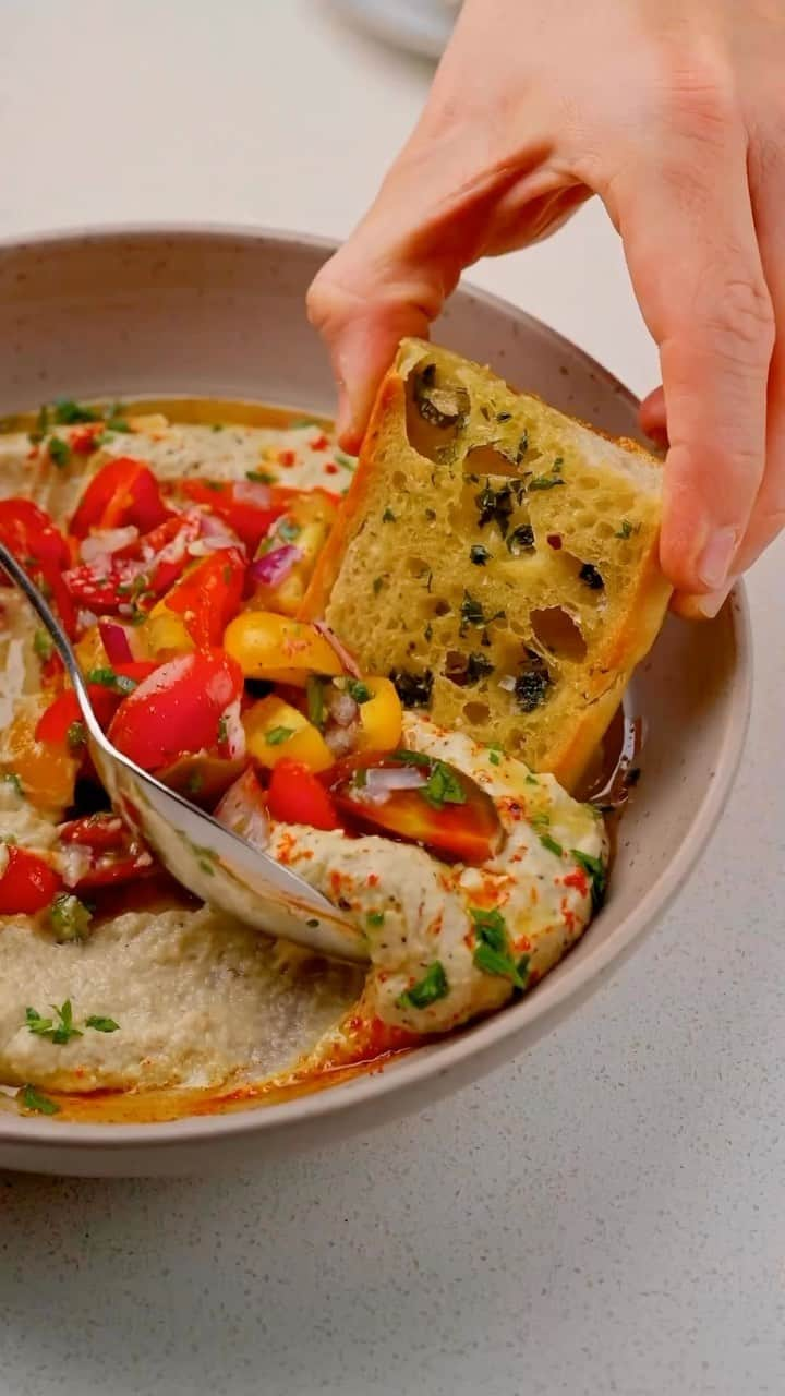 Sharing Healthy Snack Ideasのインスタグラム：「Herb Garlic Baguette & Roasted Eggplant Dip  By • @breadbakebeyond **The eggplant dip also known as Baba Ganoush)  For the Roasted Eggplant Dip:  2 eggplants 4 cloves of garlic 2 tbsp. lemon juice 1 tsp. cumin 1/4 cup raw tahini 1/4 cup olive oil Salt and pepper to taste  For the Topping: A pinch of paprika 1 tsp. fresh parsley chopped  For the Herb baguette: 1 medium-sized baguette 2 cloves of garlic, minced 1 tbsp. fresh parsley chopped 1/4 cup olive oil  Instructions: 1. Start by preheating your oven to 450 F and lining a baking sheet with parchment paper. 2. Slice the eggplants in half lengthwise, lightly brush the cut sides with some olive oil, and lay them face down on the baking sheet. 3. Place them in the oven and let them roast for around 40 minutes, or until they’re nice and soft. Take them out of the oven and let them cool down a bit. 4. After the eggplants have cooled, scoop out the insides and discard the skins. 5. In a food processor, add the eggplant and the rest of the dip ingredients, then blend until you’ve got a smooth, creamy dip. Adjust the seasoning as needed.  For the bread: 1. Turn your oven down to 400 F. 2. Take your baguette and slice it lengthwise. 3. Mix the parsley, garlic, and olive oil in a bowl, then brush this mixture over the open sides of the baguette. 4. Place the baguette in the oven for about 10-15 minutes. Then, cut it up into squares.  To serve: 1. Spread the eggplant dip on a plate, then top with a fresh chopped salad. 2. Drizzle some olive oil over the top, sprinkle with chopped parsley and a bit of paprika. 3. Serve it up with squares of herb garlic bread.  Enjoy!  #dinnerideas #easyrecipe #asmr #eggplant #baguette」