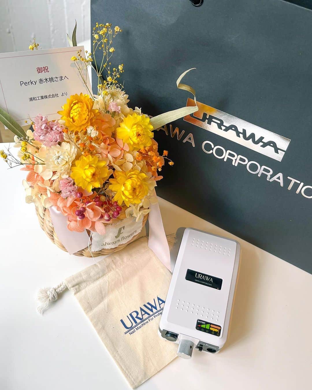 赤木 桃 #ちゃんものインスタグラム：「@urawacorp_nail 浦和工業株式会社様からお祝いのお花と真っ白なかっこいいG3をいただきました🥹✨✨ 阪口さま、山口さま いつもありがとうございます💐ちいちゃい巾着もかわいい🤏🏻  先日工場の見学もさせてもらって、ハンドピースを作ってるところを実際に見させてもらったばかりなのでありがたみが全然違う、、🏭」