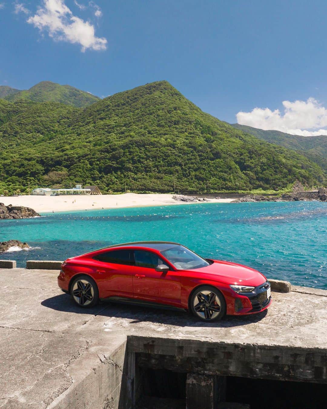 アウディ ジャパンさんのインスタグラム写真 - (アウディ ジャパンInstagram)「目の覚めるような青さの空と海。 眩い陽光に照らされた緑。 情熱的なカラーリングのAudi RS e-tron GT。  雄大な自然の中ですら異彩を放つタンゴレッド メタリックのクルマが、屋久島の景色に彩を添える。  #AudiRSetronGT #Audi #アウディ #AudiJapan #アウディジャパン #AudiSport #アウディスポーツ #AudietronGT #アウディRSetronGT #アウディetronGT #FutureIsAnAttitude #電気自動車 #EV #サステイナブル #SportsCar #スポーツカー #AudiLife #Audigram #CarLife #CarLifeStyle #GermanCars #アウディのある生活 #アウディのある風景 #屋久島 #一湊 #西部林道 #中間ガジュマル #国内旅行」7月18日 18時00分 - audijapan