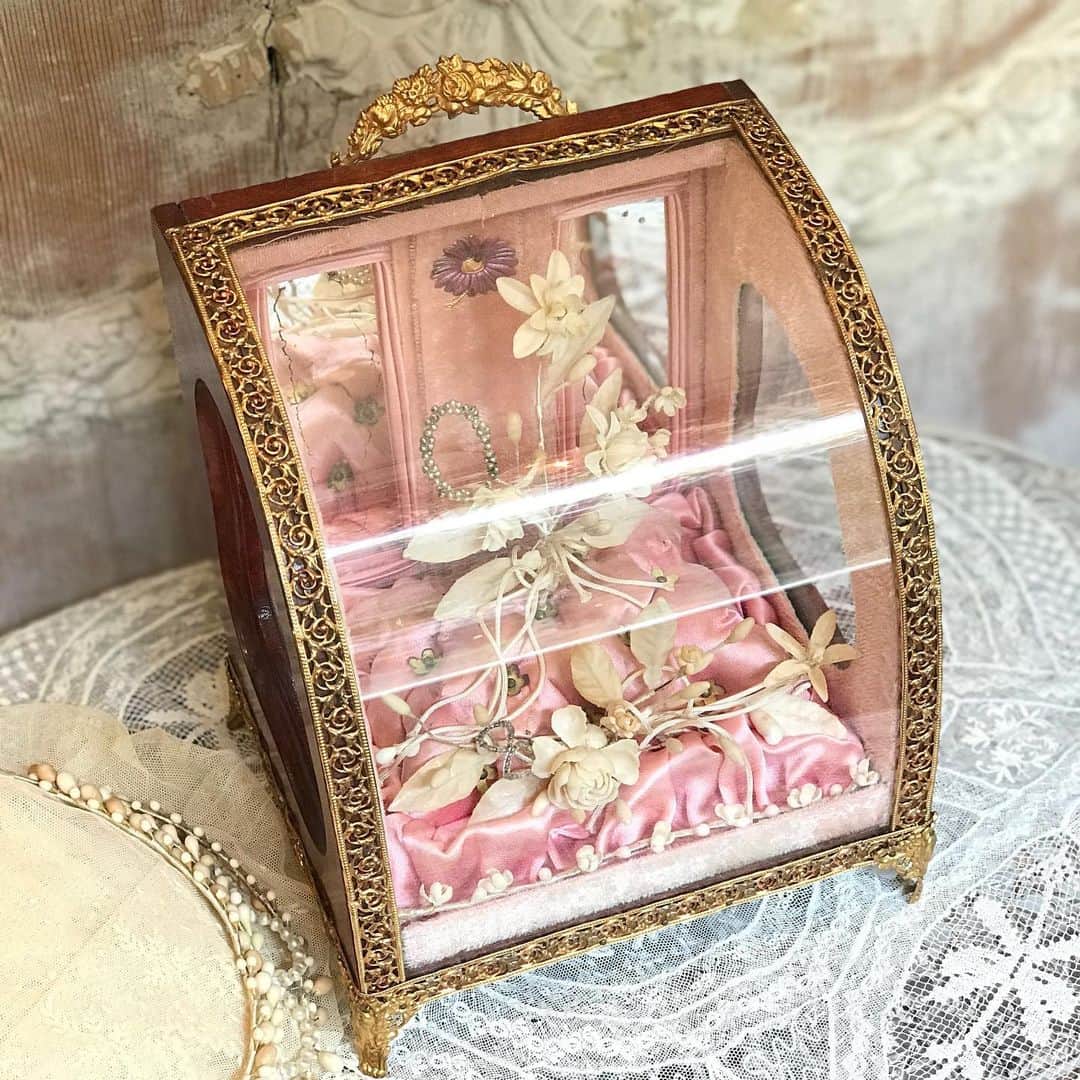 稚野鳥子さんのインスタグラム写真 - (稚野鳥子Instagram)「グローブドマリエ🕊  ウェディングアイテムを思い出と共にディスプレイするロマンティックなお品です。  ケースは美しい曲面ガラスに透かし模様のメタルフレームが縁取っています。  中を覗くと、ピンクシルクのクッションの上にワックスフラワーやビーズ細工のコサージュ、ミラーやピンクベロアが美しさを引き立てています✨  背面には2枚のミラー、中央に紫のマーガレットを象ったメタルパーツがあしらわれている大変レアなデザインです。  サイドの小窓が一層華やかさを演出しています✨  #toricoloreshop #toricolore #フランスアンティーク #アンティークショップ #恵比寿 #アンティークのある暮らし #フレンチカントリー#frenchantiques #antiqueshop #shabbychic #シャビーシック #グローブドマリエ #グローブドマリアージユ #アンティークマリアージュ #ワックスフラワー #アンティークワックスフラワー #ワックスフラワーティアラ」7月18日 16時13分 - toricolore_shop