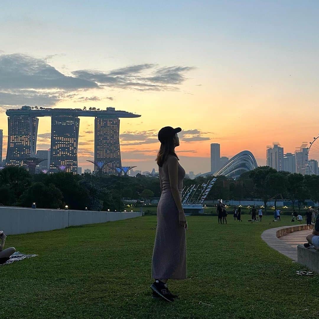 市原彩花さんのインスタグラム写真 - (市原彩花Instagram)「Sunset🌇 📍Marina Barrage, Singapore   The Singaporeな夕陽が見れるスポット、マリーナバラージ🌇 広い芝生でピクニックしながら過ごせるよ🎈  Gardens by the bayと繋がってるから日が沈んだらそのままスーパーツリーの無料のライトアップショーを見に歩いて行けたり、さらにマリーナベイサンズまで行けば噴水ショーも見れるよ😉  日の入り…19時過ぎ スーパーツリーのショー…19:45(と20:45) 噴水ショー…20時(と21時。金土は22時も) ↑どっちかを夕陽見てから行くのにちょうどいい時間なの🤭  #sunset#夕陽#夕日#シンガポール#singapura#海外生活#海外旅行#海外移住#シンガポール生活#シンガポール在住#シンガポール旅行#シンガポール観光#singaporetravel#singaporetrip #あーちゃんシンガポール」7月19日 20時00分 - ayaka_ichihara