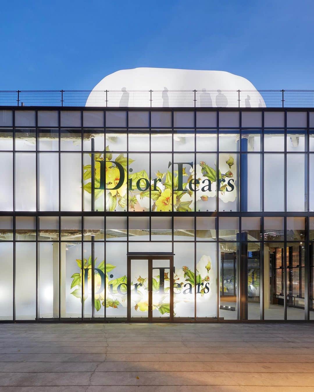 のインスタグラム：「The #DiorTears pop-up has landed in Tokyo. Open through July 30, the space presents key pieces, such as plaid shirts and varsity jackets, alongside inflatable structures. Through an interplay of sounds and lights, the works transform into living spaces, while video projections by @AzumaMakoto echo the flower logo specially conceived for the denim-focused line, part of the #DiorMenFall 2023 collection by @MrKimJones and guest designed by @DenimTears. © Tomoyuki Kusunose」