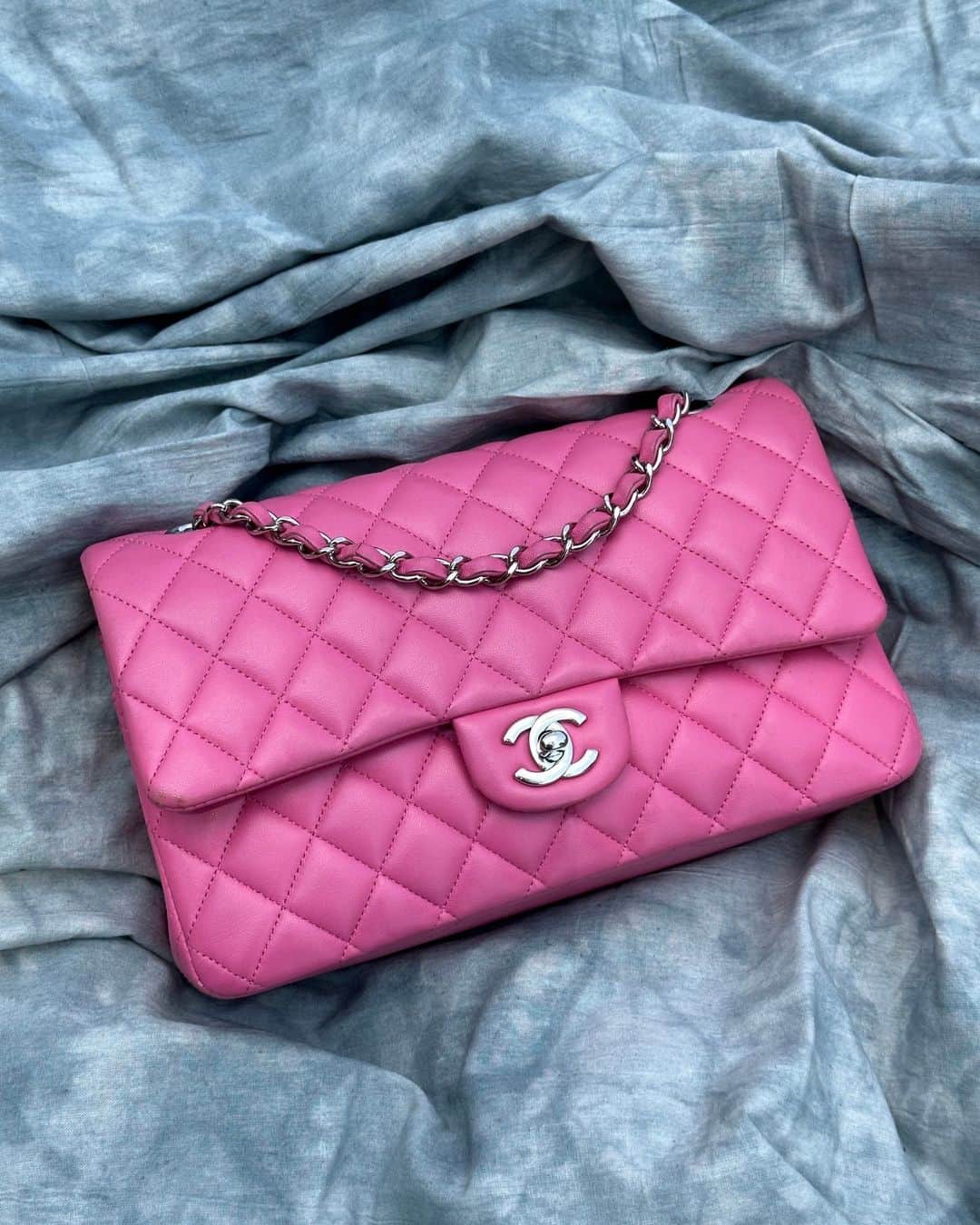 ワットゴーズアラウンドカムズアラウンドのインスタグラム：「Add a pop of color to your look with this head-turning bubblegum pink medium Chanel Classic Flap. This perfectly pink bag is available online now, tap to shop!」