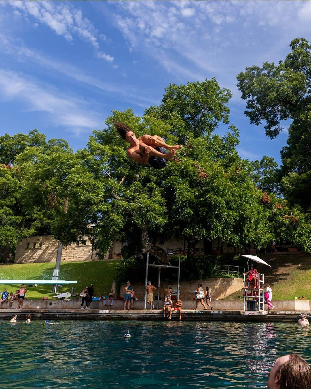 ニューヨーク・タイムズさんのインスタグラム写真 - (ニューヨーク・タイムズInstagram)「Barton Springs Pool, whose cool, natural waters have created summer memories for generations in Austin, Texas, has become an important refuge during the current heat wave.  When Austinites talk about Barton Springs, they do so in almost spiritual terms. “It’s very much a sacred place,” said Kim McKnight, manager of historic preservation and tourism for the city’s Parks and Recreation Department. “I recognize not everybody goes there, but for those who do they can’t imagine life without it.”  A part of the Austin landscape since the early 20th century, the pool is so beloved that residents resorted to near rebellion to save it from developers in the 1990s. Marriages and funerals are regularly held on its grassy banks.  In Austin, where temperatures as high as 107 were forecast to persist through much of the week, the cars kept pulling into the parking lot at the springs, where the water temperature — winter or summer — averages a comfortable 68 to 71 degrees.  Read more about this Austin oasis at the link in our bio. Photos by @ilanapl」7月20日 9時00分 - nytimes