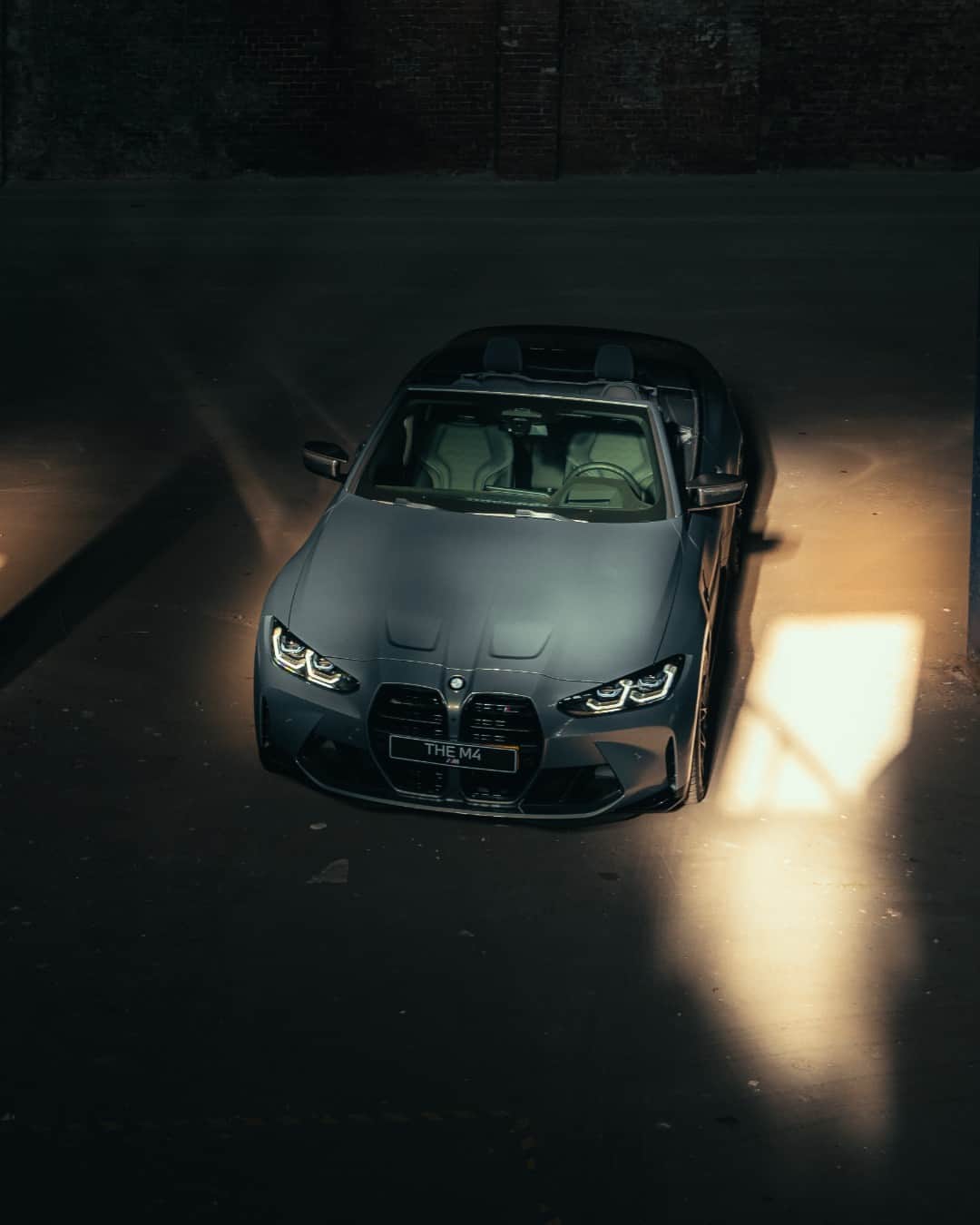 BMWのインスタグラム：「There be power amongst the shadows ✰ 📸: @row1photography @vanlaarhovenbmwmini @story.bmw #BMWRepost   The BMW M4 Competition Convertible. #THEM4 #BMWM #M4 #BMW #MPower __ BMW M4 Competition M xDrive Convertible: Combined fuel consumption: 10.2 l/100 km. Combined CO2 emissions: 233–231 g/km. All data according to WLTP. Further info: www.bmw.com/disclaimer」