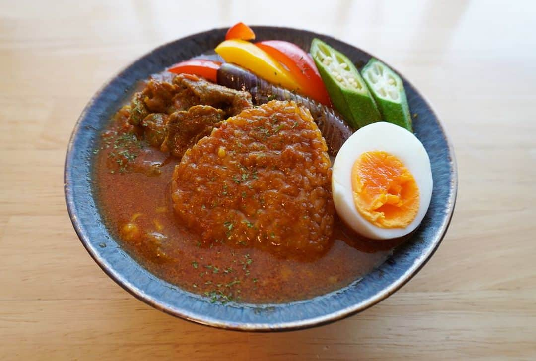 印度カリー子のインスタグラム：「【レシピ】夏野菜たっぷり♪トマトビーフ・スープカレー  トマトの旨味が凝縮！  隠し味のめんつゆと香ばしい焼きおにぎりの味わいが相性抜群です。  お好きな夏野菜でアレンジしてね♪  材料（2人分） ・大きな大きな焼きおにぎり（ニッスイ、冷凍）2個 ・牛うすぎり肉　150g ・トマト　1個（200g。くし切り） ・にんにく　3かけ ・コンソメ　1個 ・めんつゆ（3倍濃縮）　大さじ1 ・油　大さじ1 ・水　250ml  スパイス ・ターメリック、クミン、コリアンダーパウダー　各小さじ1 ※カレー粉　大さじ１でも代用可能  トッピング ・お好きな夏野菜（なす、パプリカ、オクラ、ピーマン、インゲンなど）、ゆで卵など  作り方 ①フライパンに油をひいて、弱火でにんにくを熱する  ②香りが立ってきたら、トマトを汁気がなくなるまで中火で炒める  ③水、スパイス、コンソメ、めんつゆを加え、ふたをして弱火で10分煮込む  ④牛肉を加えて、1～2分ほど煮る。肉の色が変わったらすぐ火を止める  ⑤大きな大きな焼きおにぎりを電子レンジで規定の時間温め、④をかける。別のフライパンで焼いておいた夏野菜やゆで卵をトッピングする  #大きな大きな焼きおにぎり　#ニッスイ　#pr」